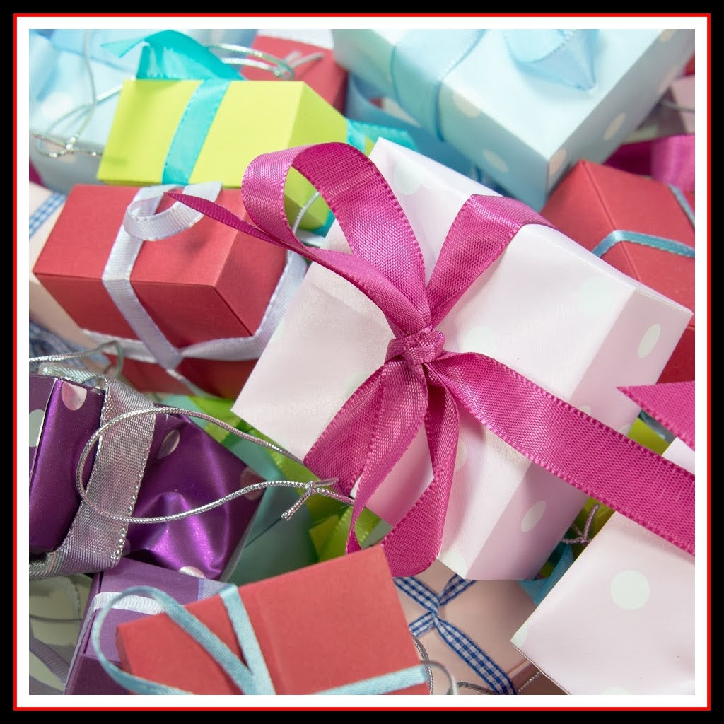 An image of assorted wrapped gifts in boxes with brightly colored ribbon