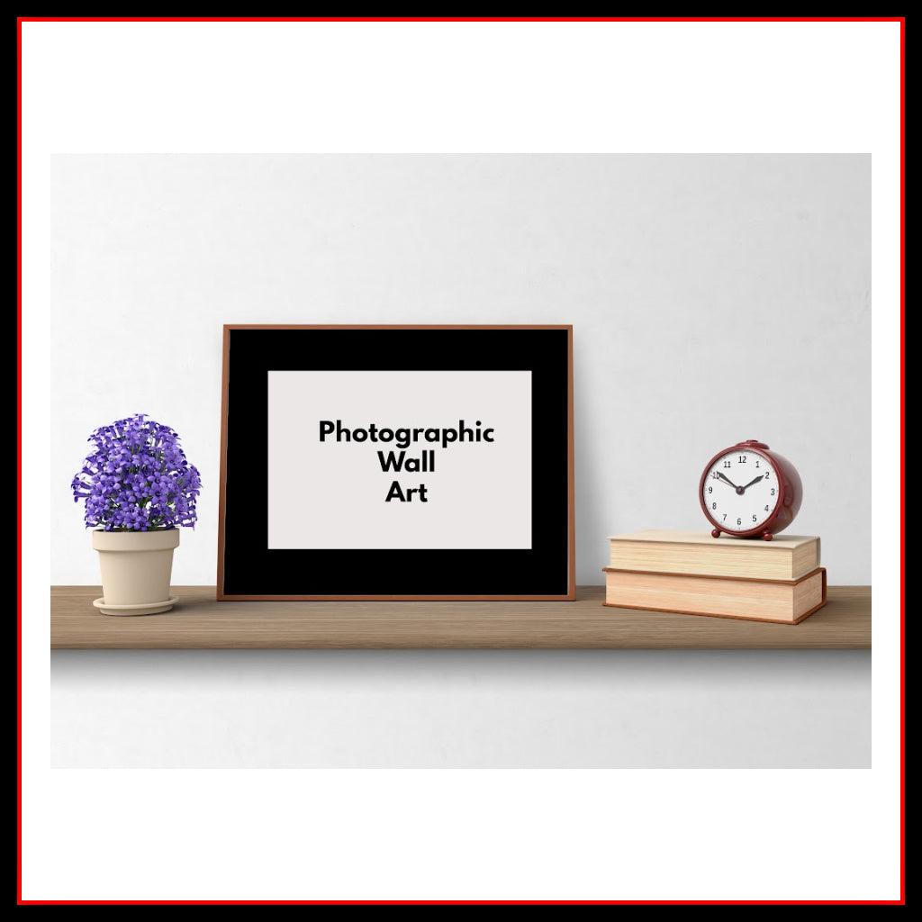 Photo of a 'sample' mock up of a framed piece of Photographic Wall Art with a plant on the left and a clock on top of books on the right