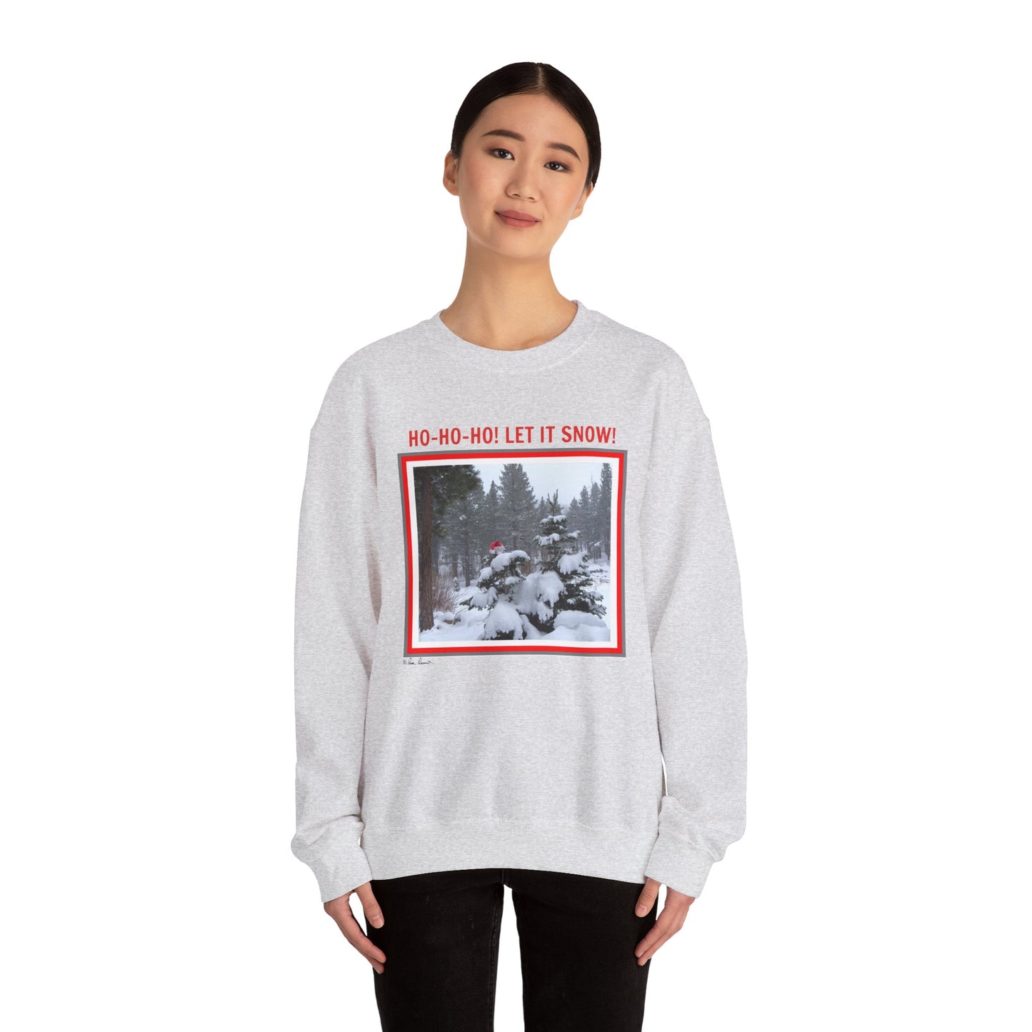 A person wearing a cozy Unisex Holiday Crewneck Sweatshirt: Heavy Blend™ by Printify, with a winter-themed graphic and "Ho-Ho-Ho! Let It Snow!" text. This gray Santa sweatshirt captures the season's spirit and supports sustainable fashion trends.