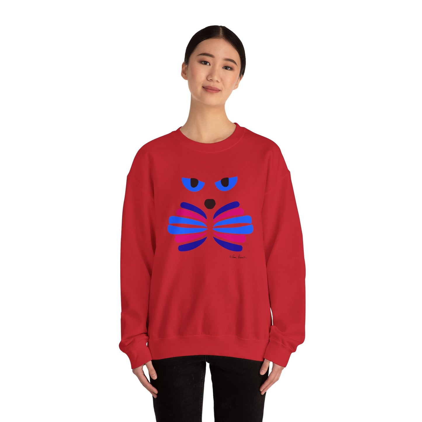 A woman faces forward, wearing the Printify Whimsical Cat Graphic Sweatshirt—a unisex crewneck featuring a blue and purple abstract cat face art design on the front.