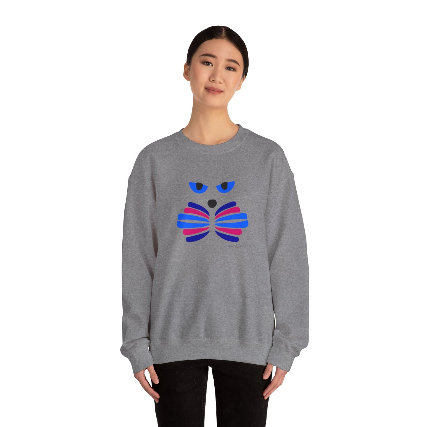 A person wearing a grey Printify Unisex Cat-Art Sweatshirt, which features a colorful abstract face design, stands against a white background.