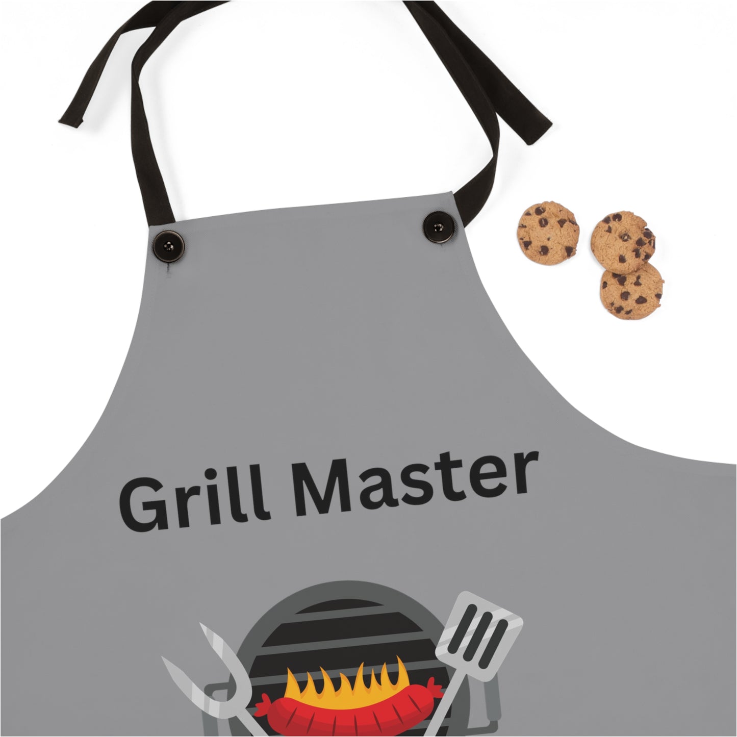 A grey Printify Grill Master Apron: Unisex; Polyester; Lightweight; Graphics with "Grill Master" text and a barbecue graphic sits proudly next to three chocolate chip cookies, making it the perfect grilling gift.