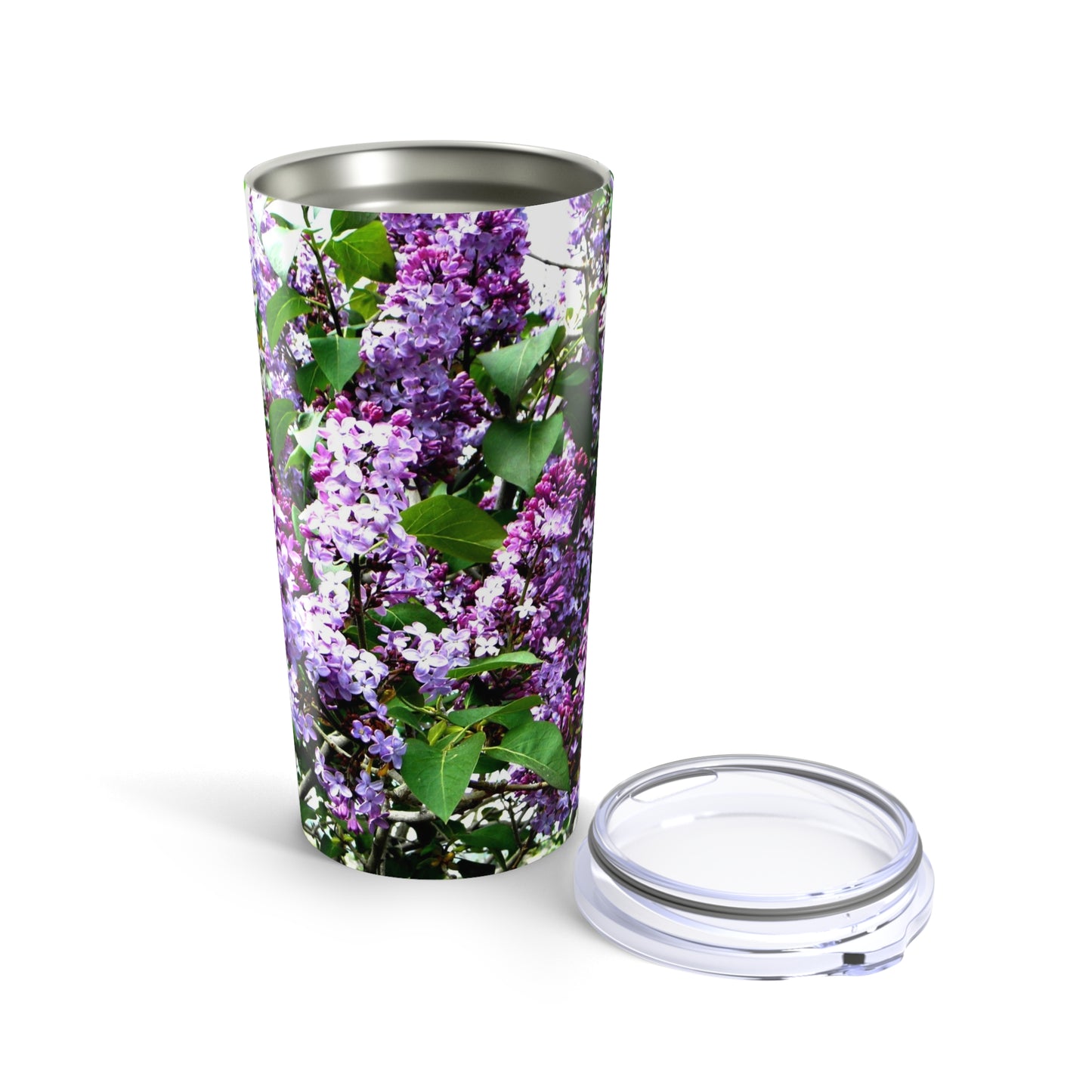 The Printify Purple Lilacs Tumbler is a 20 oz. stainless steel, insulated tumbler decorated with purple lilac flowers and green leaves, and includes a clear plastic lid.