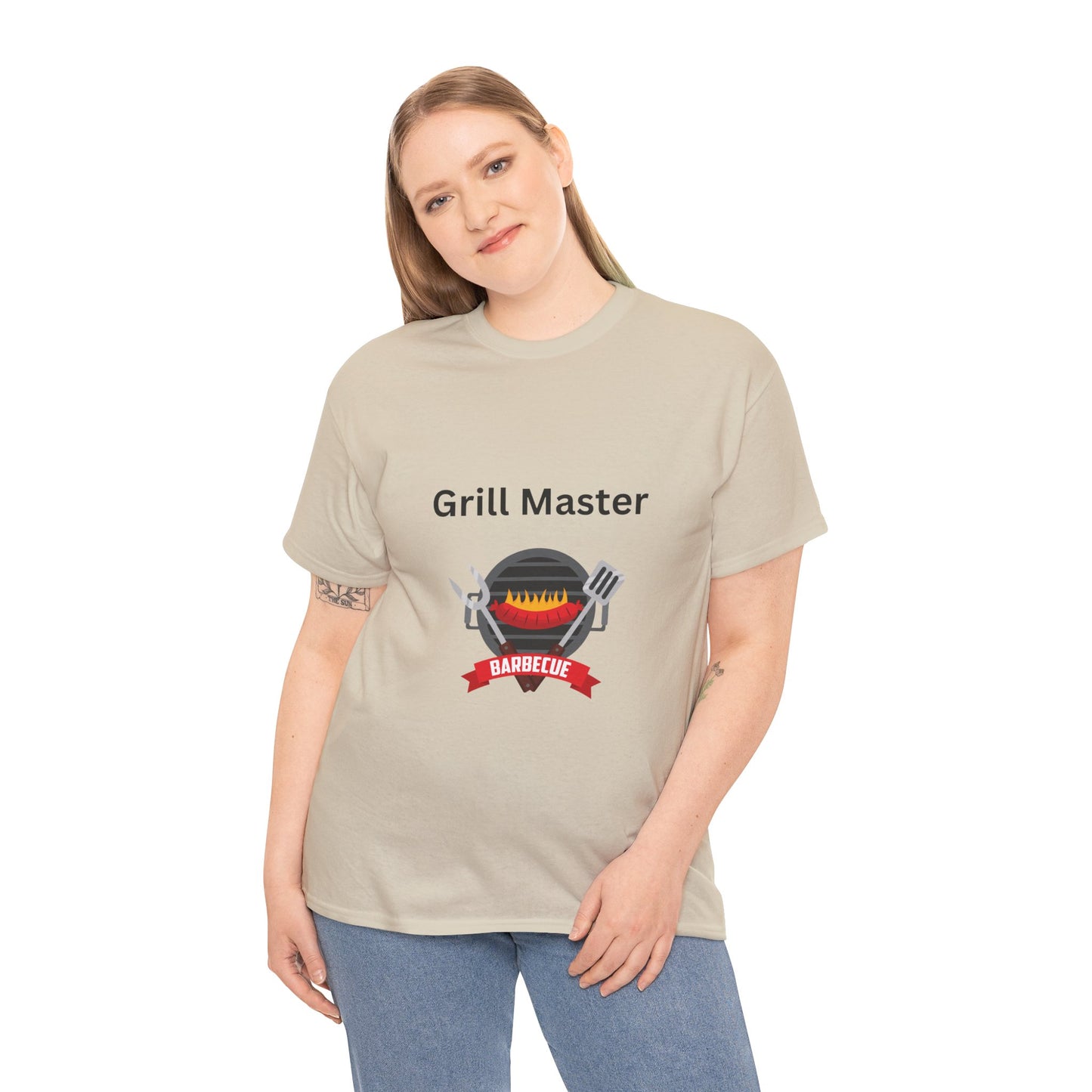 A woman with long hair wears a beige, unisex "Unisex Grill-Master T-shirt: 2 colors; Cotton; Gildan" by Printify, featuring a grill graphic. Made in America, she touches the hem of the shirt with one hand and has a slight smile.