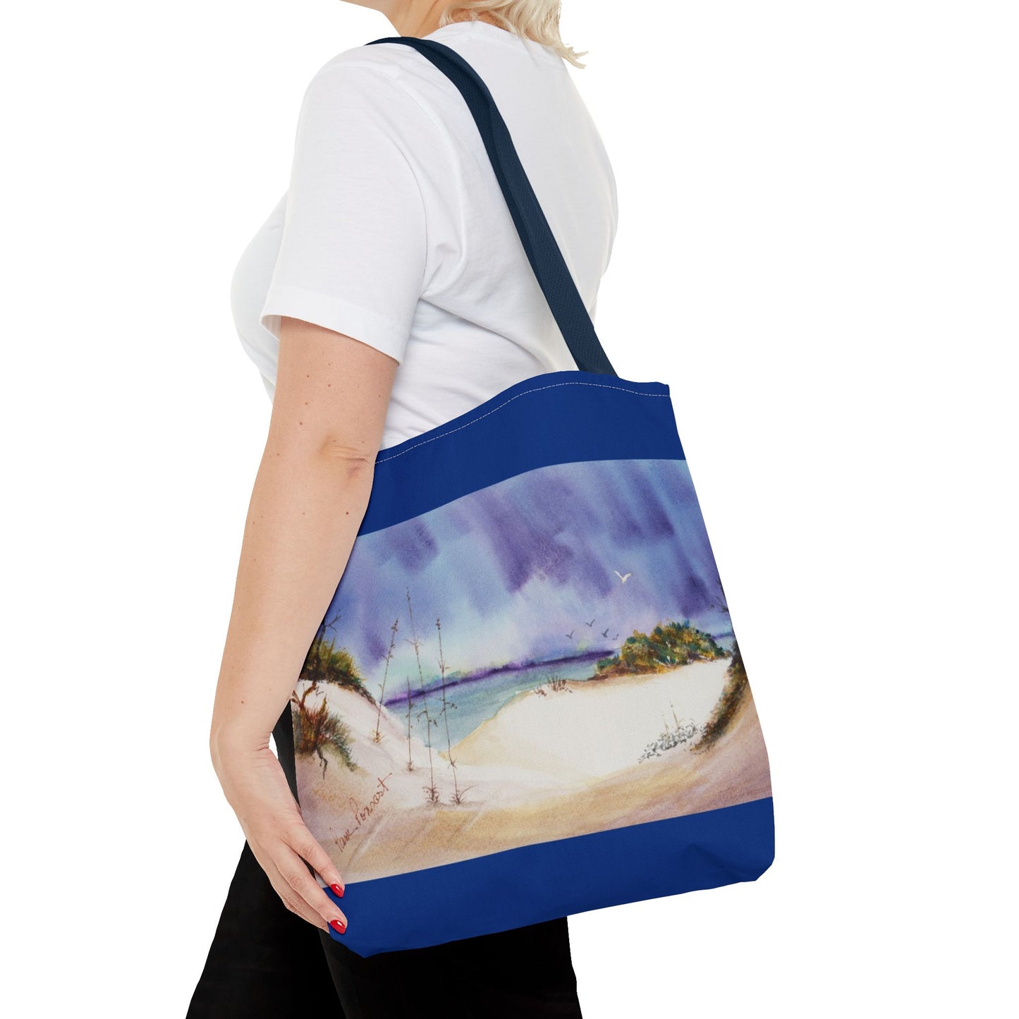 A person in a white t-shirt carries Printify's Seaside Tote Bag, featuring a beach scene on polyester with a 2-sided print, ideal for summer adventures and beach outings. Comes in 3 sizes.