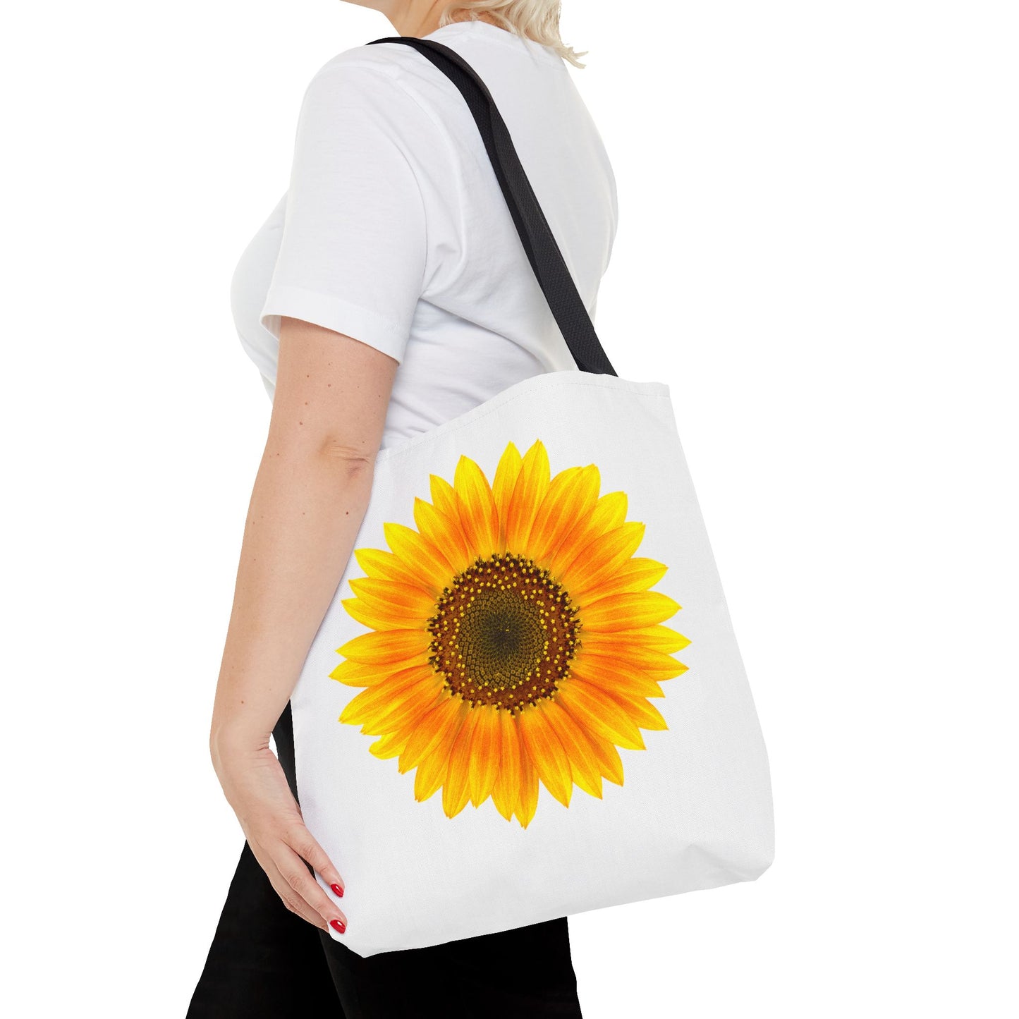 A person in a white shirt carries a Printify Sunflower Tote Bag, featuring 2-sided polyester print with nature-inspired, vibrant sunny designs, available in 3 sizes.