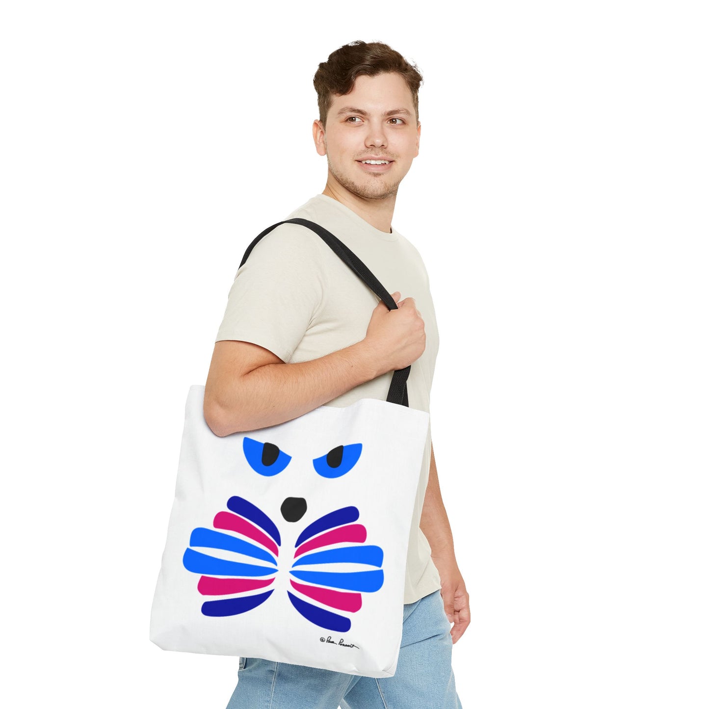 A person holds a Printify Cat-Face Tote Bag, featuring a vibrant abstract design on durable polyester, while wearing a light beige t-shirt and smiling to the side—ideal for cat enthusiasts.