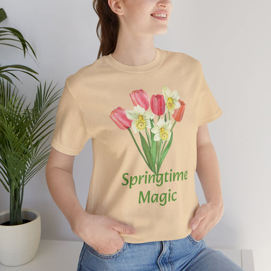 Woman wearing a beige cotton Unisex Springtime-Magic T-shirt with a floral design and the phrase "springtime magic" printed on it, showcasing graphic artistry from Bella + Canvas by Printify.