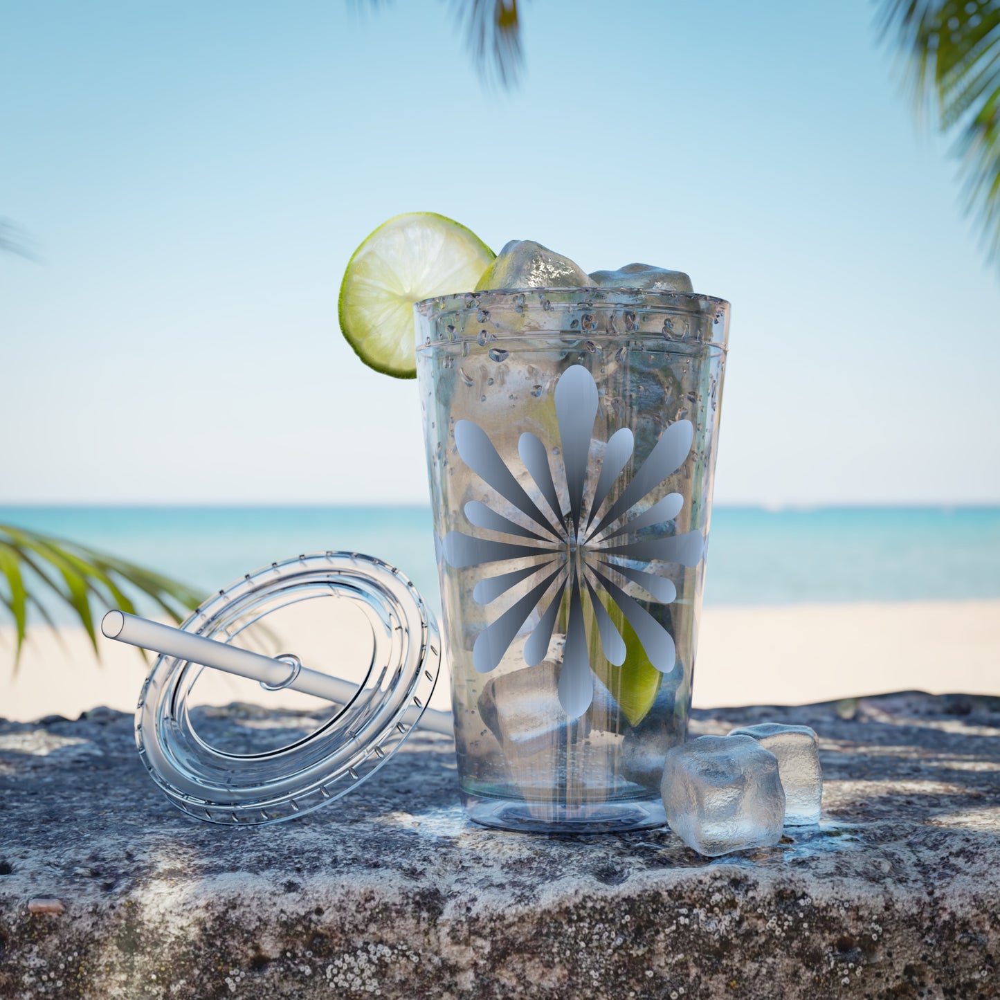 A crack-resistant Printify Blue Star-burst Tumbler with ice and lime slices on a rock.