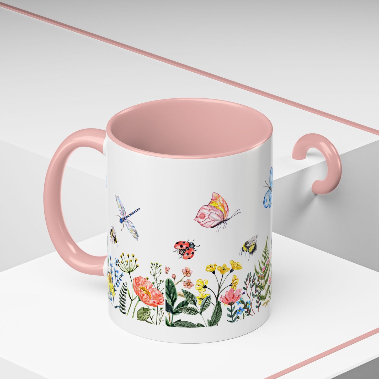 The Printify Colorful Spring Garden Mug (11 oz., ceramic, AOP design) features vibrant butterfly, flower, ladybug, bee, and dragonfly illustrations on a white surface with a light pink handle and rim. It's perfect for garden lovers who appreciate nature's beauty in every sip.