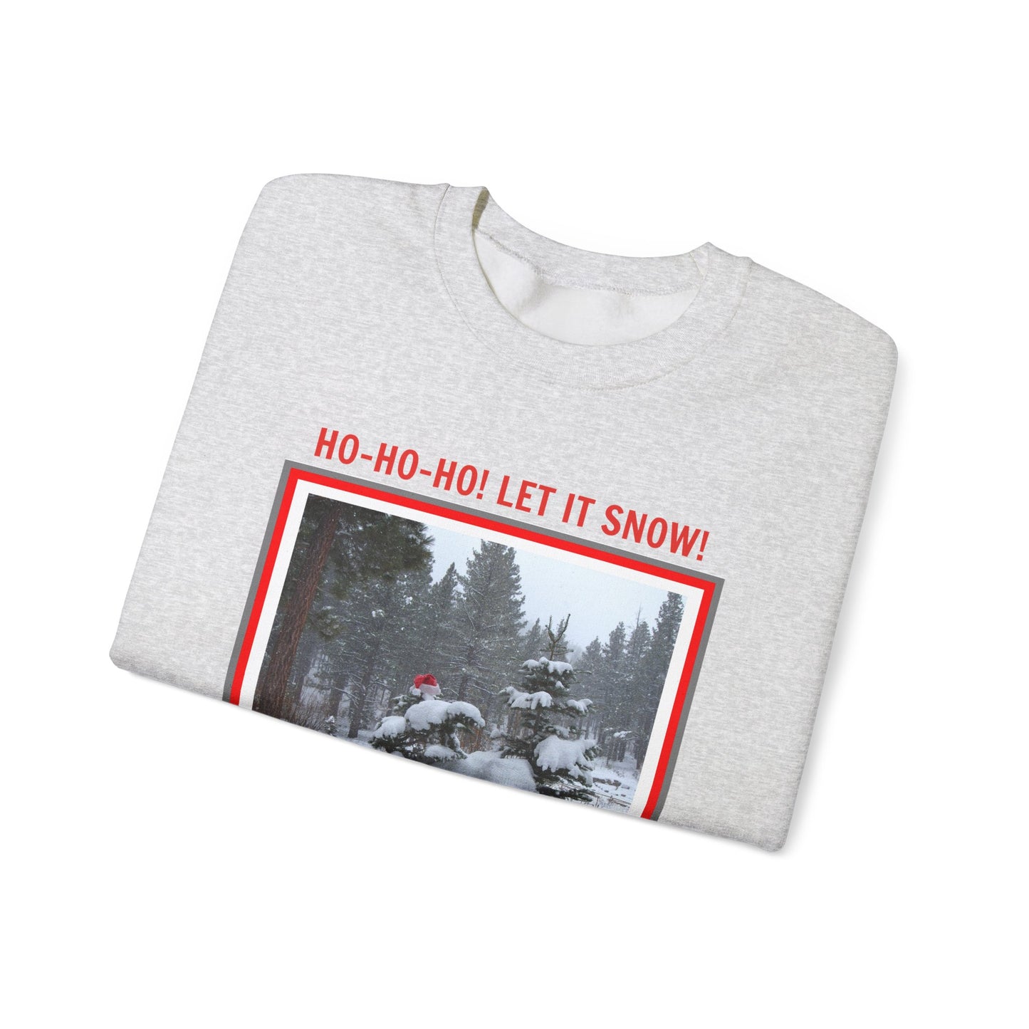 This cozy essential from Printify, the Unisex Holiday Crewneck Sweatshirt: Heavy Blend™ | Santa, features a folded gray design with a snowy forest image and cheerful "HO-HO-HO! LET IT SNOW!" text—perfect for embracing sustainable fashion.