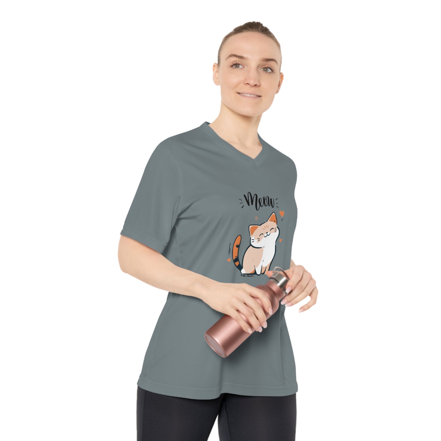 A person wearing a Printify Women's Tabby-Cat T-shirt: V-neck; UV 40+; Team 365 in moisture-wicking polyester, featuring a cat graphic and the word "Meow," holds a metallic water bottle.