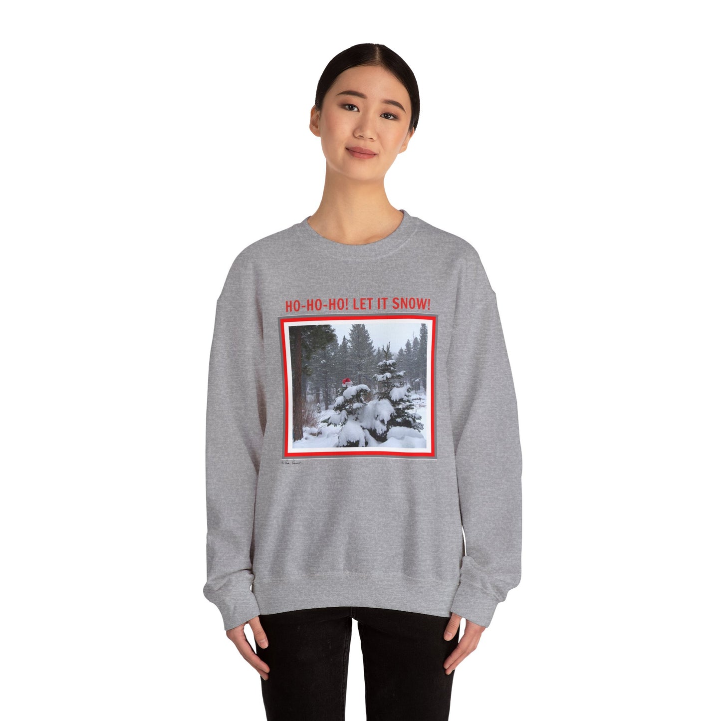 The Printify Unisex Holiday Crewneck Sweatshirt, Heavy Blend™ | Santa, is a cozy must-have for sustainable fashion lovers featuring a festive "Ho-Ho-Ho! Let It Snow!" snowy scene with a vibrant red border.
