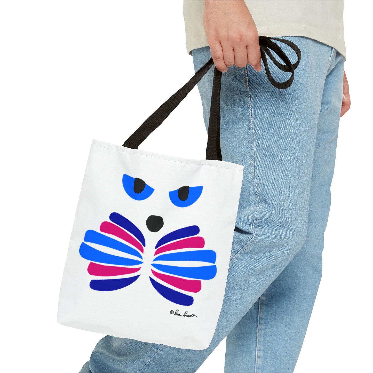 A person holding a Printify Cat-Face Tote Bag, featuring a vibrant, abstract cat face in bold blue, pink, and black. Designed for cat lovers, this durable 2-sided printed polyester bag provides both style and utility. Available in 3 sizes.