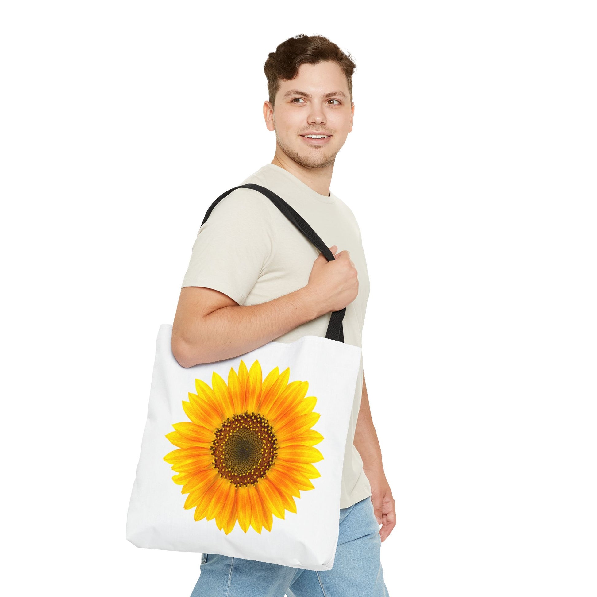 A man in a beige shirt and jeans carries a Printify Sunflower Tote Bag, exuding a vibrant vibe with its nature-inspired design.
