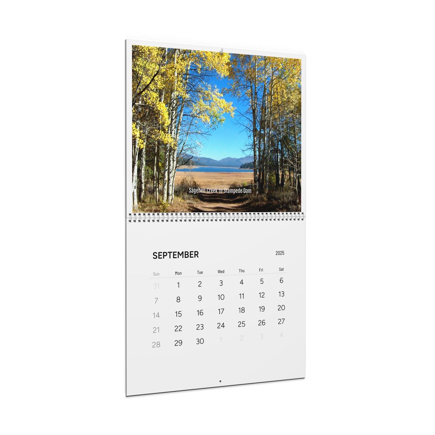 The Printify Minimalist 2025 Wall Calendar: Photographic for September emits an inspiring ambiance with a scenic lake surrounded by autumn trees and mountains in the background.