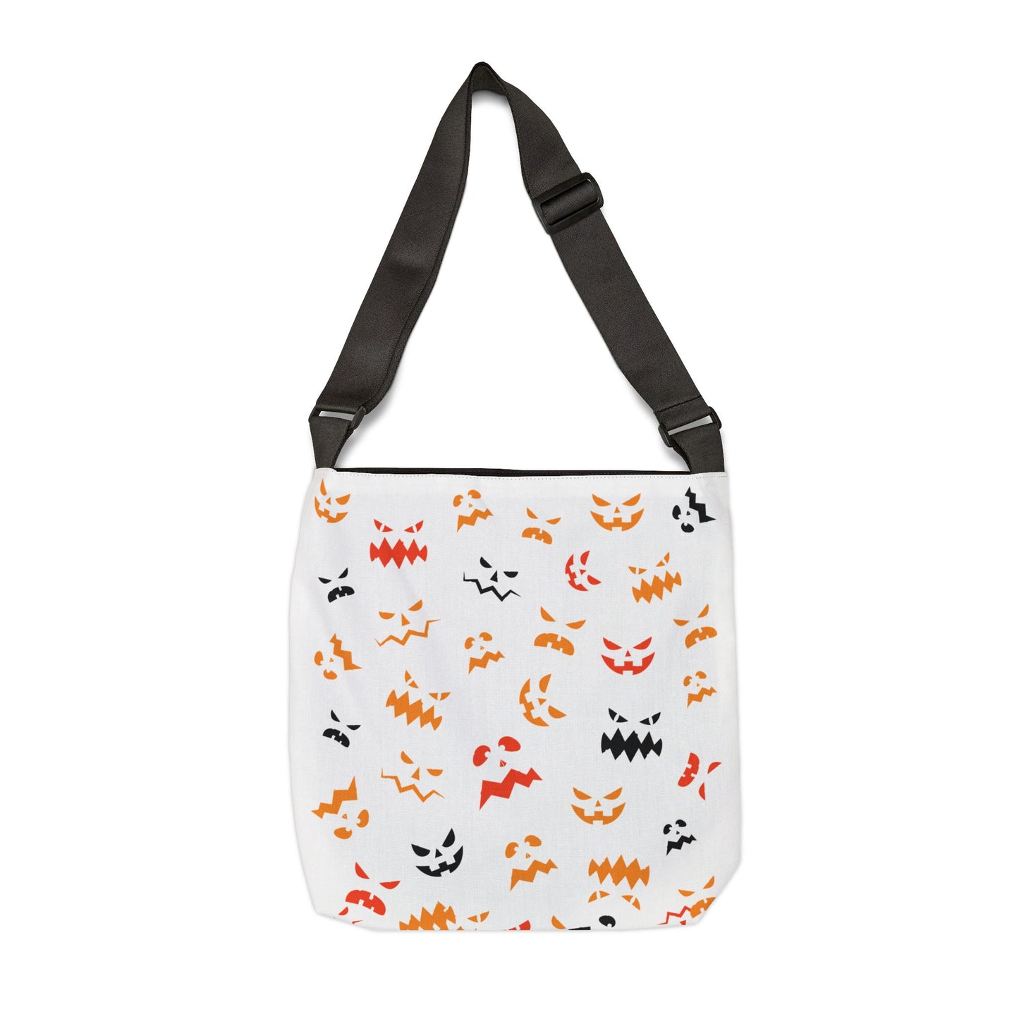 The Printify Halloween Adjustable Tote Bag: Spooky Trick or Treat sack is a white shoulder bag with a black adjustable strap and an all-over print of orange, yellow, and black Halloween-themed faces—perfect for festive style.