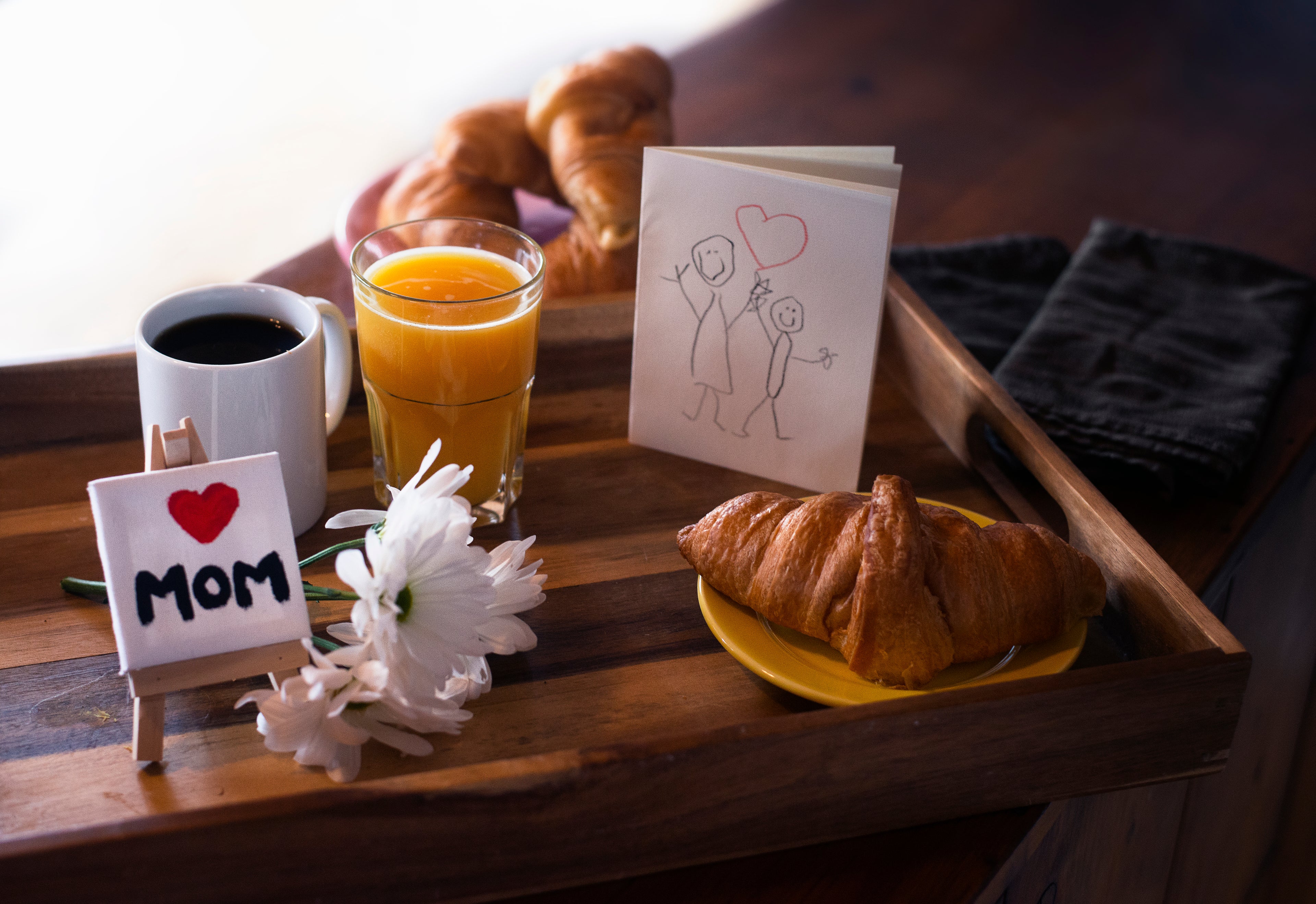 photo of a table set with love for Mom including coffee, orange juice, a crossoint and cards and flowers