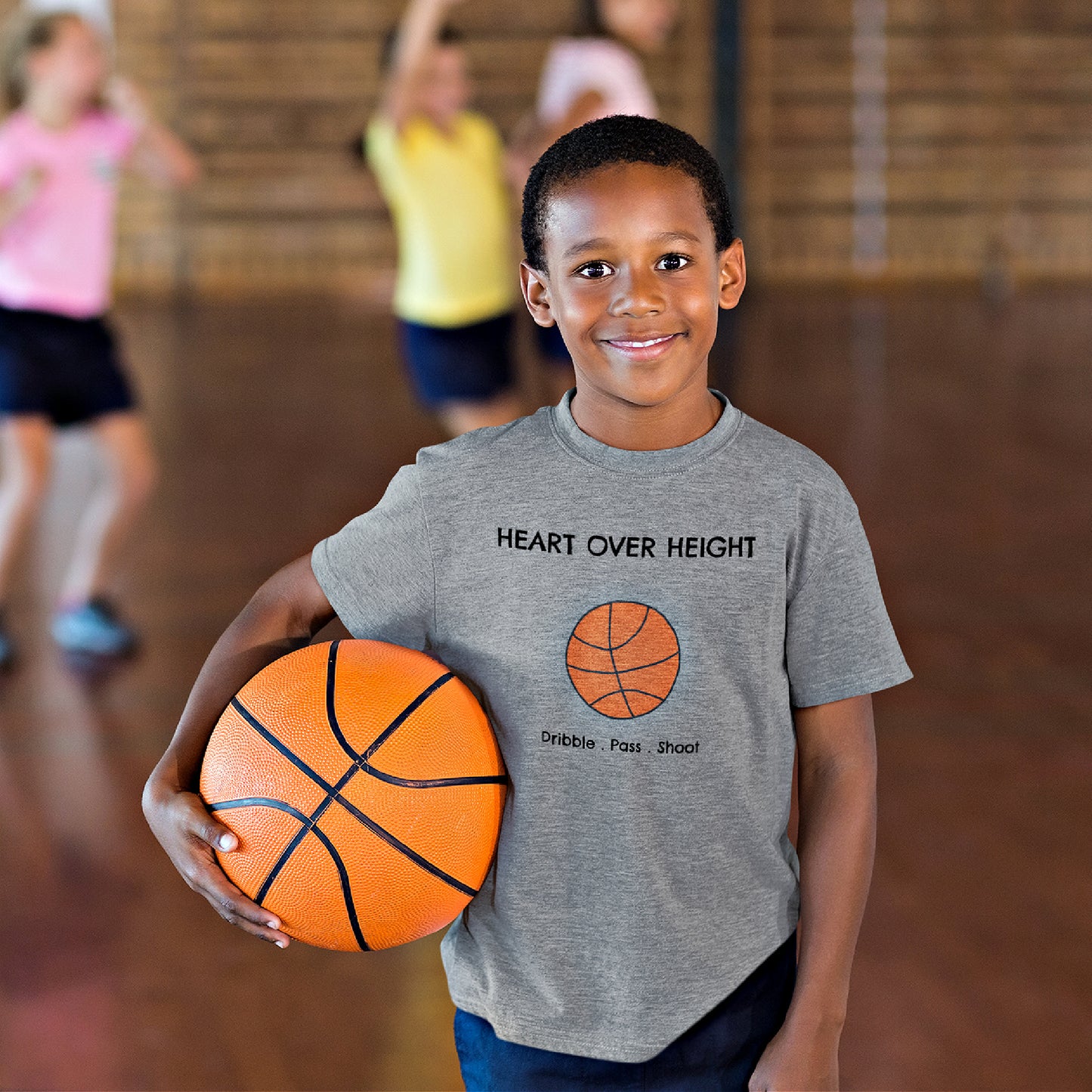 Mock up of a cute boy at basketball practice who is wearing our Sports Grey t-shirt