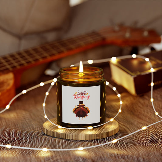 The Printify Thanksgiving Scented Candle (4 oz., 20 hrs, eco-friendly) sits in a glass jar labeled "Happy Thanksgiving" on a wooden coaster, surrounded by string lights, a guitar, and a matchbox.
