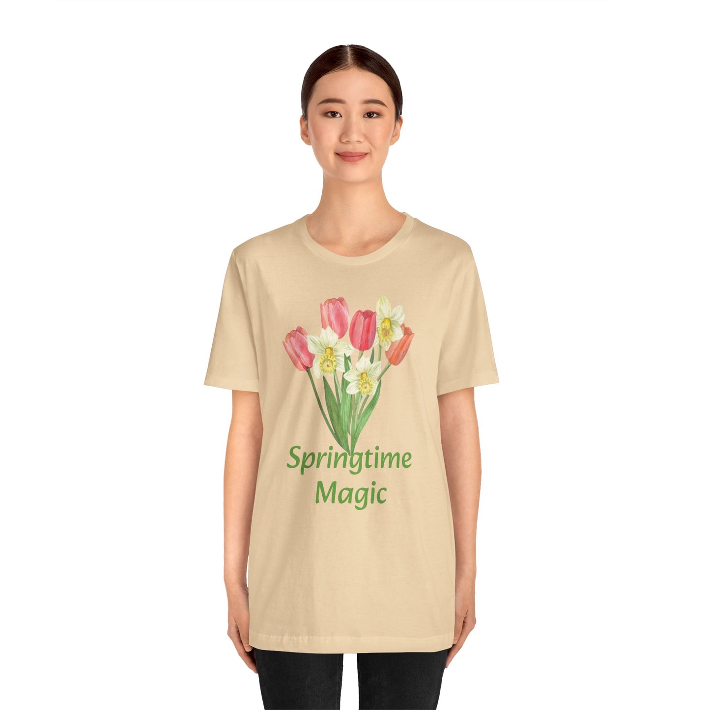 Woman wearing a beige Unisex Springtime-Magic T-shirt with tulip print and the text "springtime magic" by Bella + Canvas, Printify.