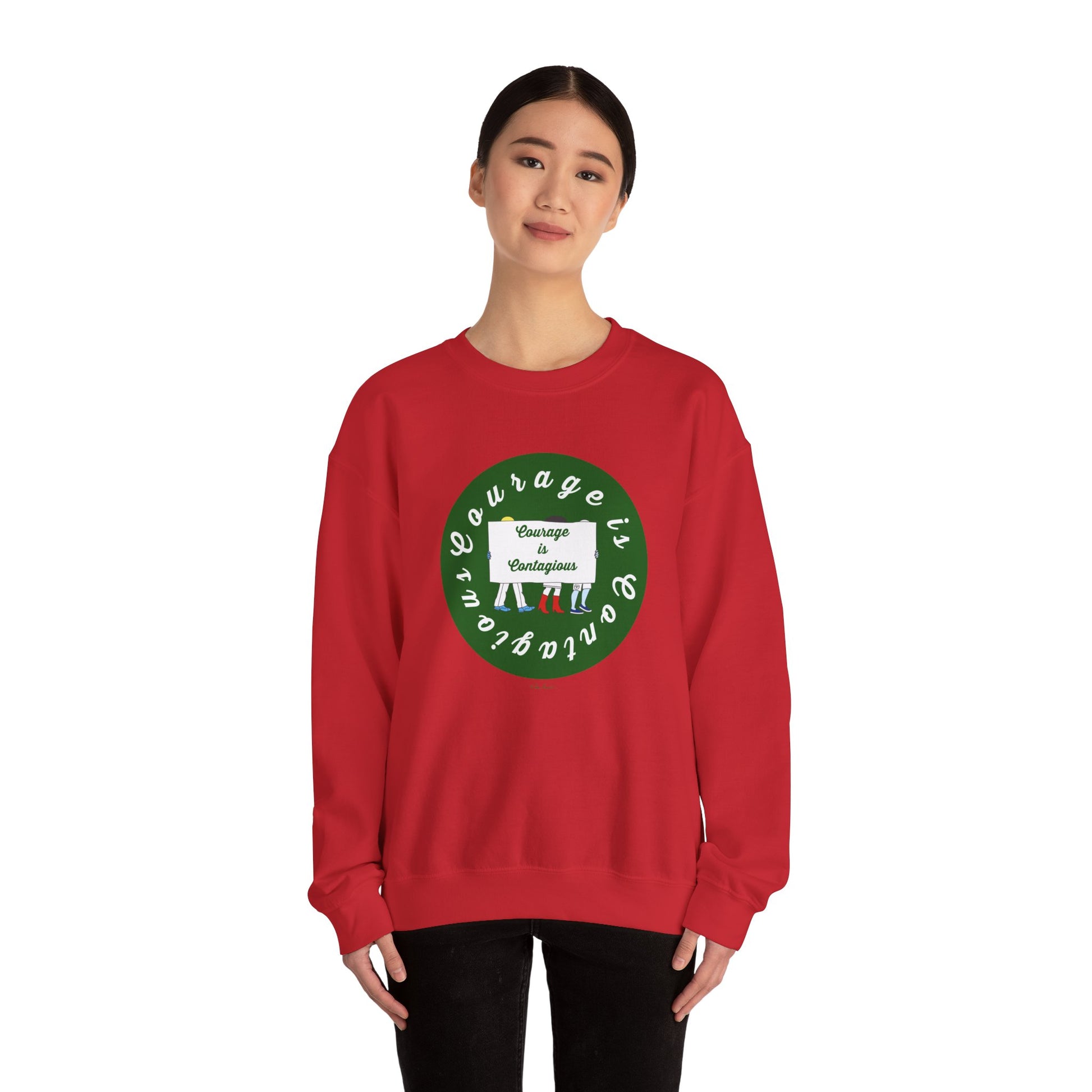 A person wears the Printify Unisex Crewneck Sweatshirt: Courage is Contagious | Protest, featuring a red color with a green circular design and the phrase "Courage is contagious," standing against a white background.
