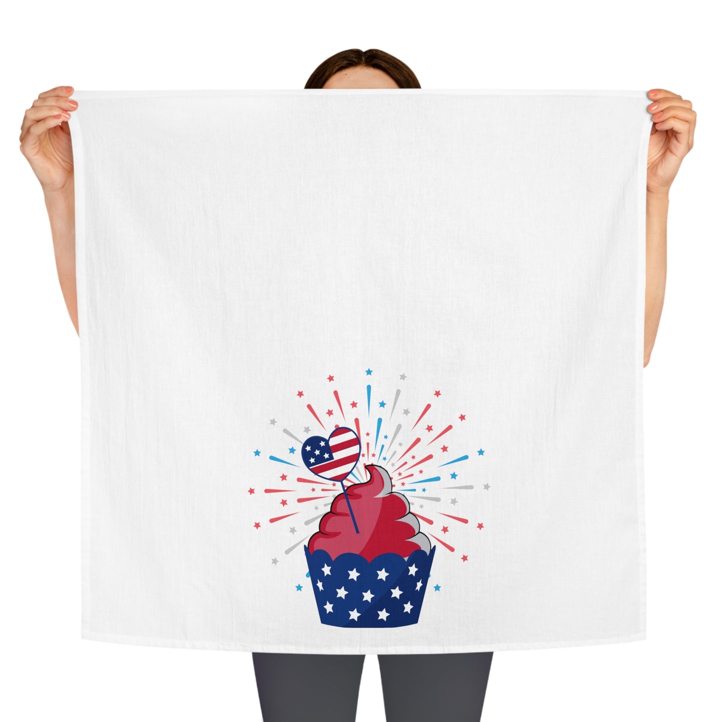 A person holding a Printify Decorative Kitchen Towel with a cupcake and fireworks, providing a festive touch to any setting.