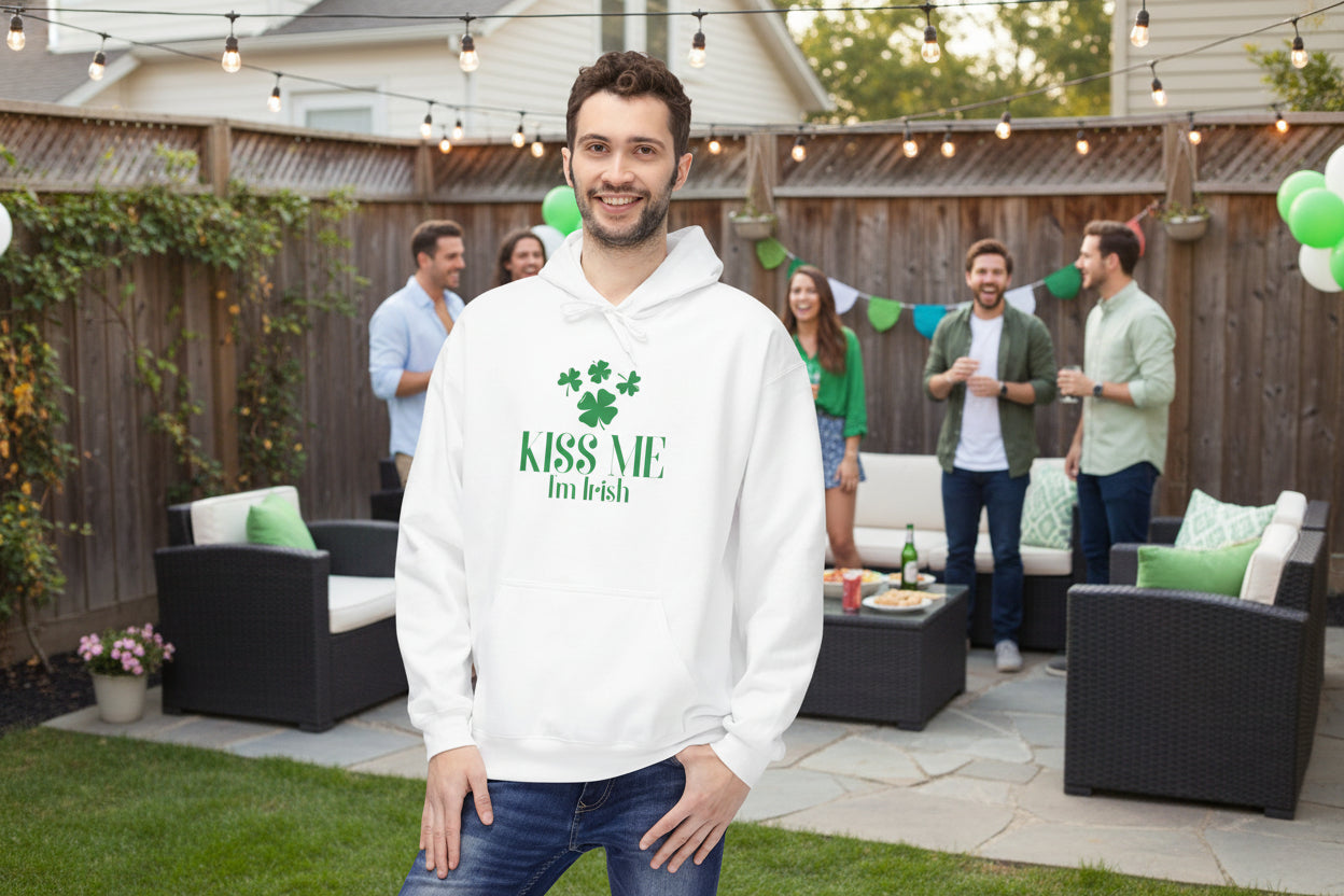 A man wears a Printify Kiss-Me I'm Irish Hoodie: St. Patricks Day Shamrock Pullover in a backyard, enjoying festive decorations and friends, showcasing his Irish pride.