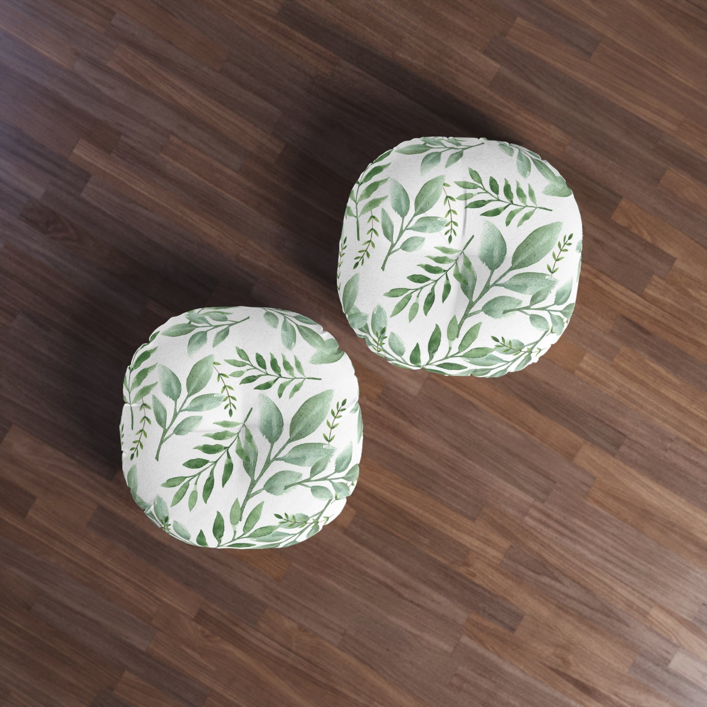 Two Printify round tufted floor-pillows with a green botanical design on a wooden floor.
