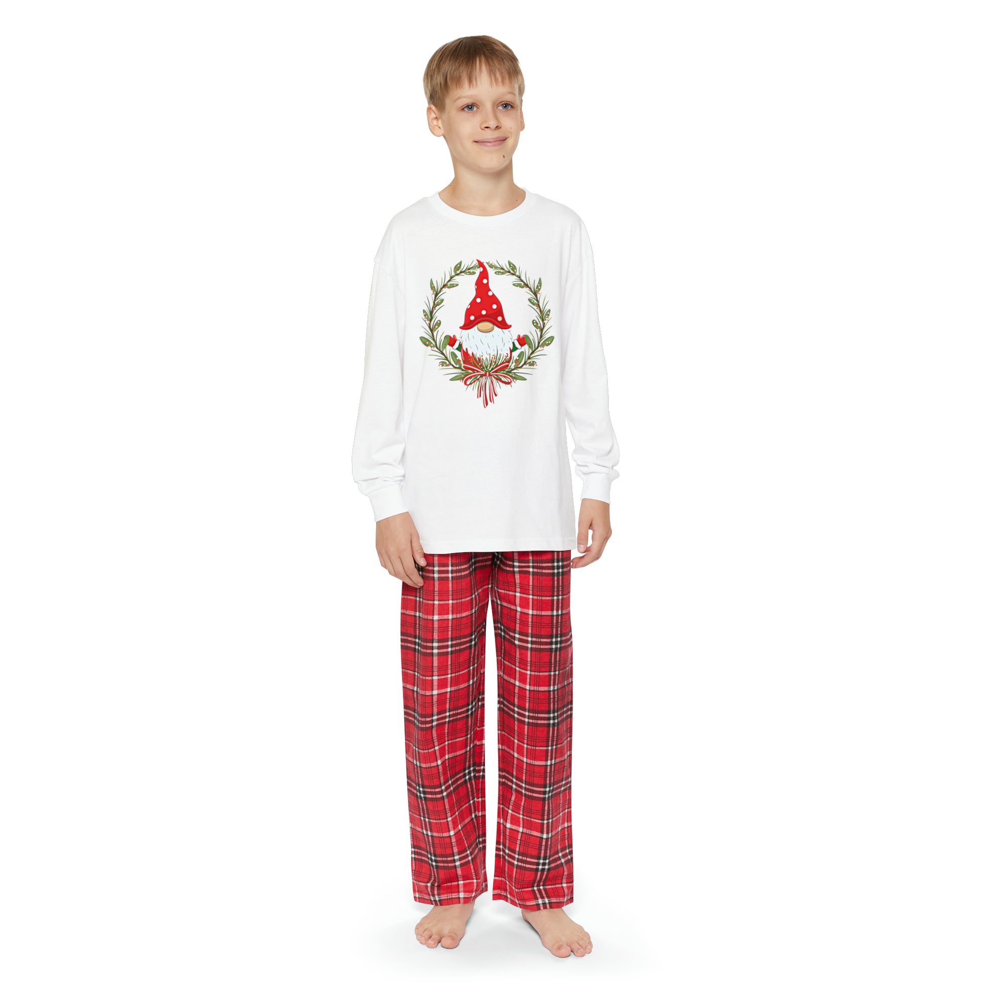 A young boy wearing a Printify Youth Holiday-Gnome Long-Sleeve Pajama Set with a christmas tree on it.