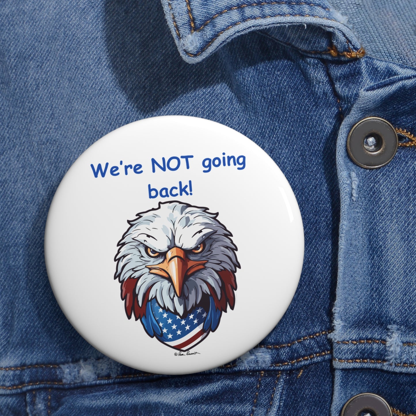 A Printify Not Going Back Button, crafted from lightweight metal and available in unisex sizes, features a fierce eagle illustration and the text "We're NOT going back!" pinned to a denim jacket, showcasing a strong patriotic theme.