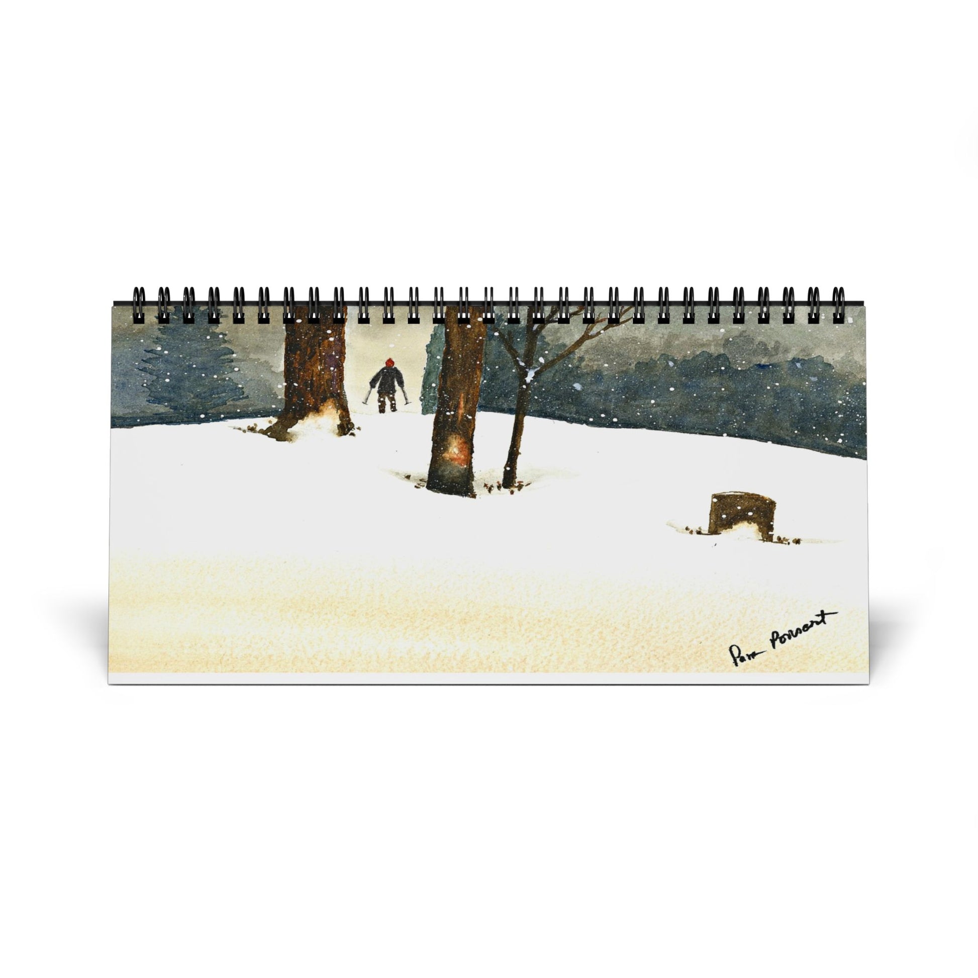 The "2025 Desktop Calendar: Snowshoe Hiker" by Printify features a watercolor painting that beautifully depicts a snowy scene with one person walking among trees. Snow gently falls beneath a gray sky, and the bottom right corner is signed, adding a personal touch to this tranquil winter landscape.