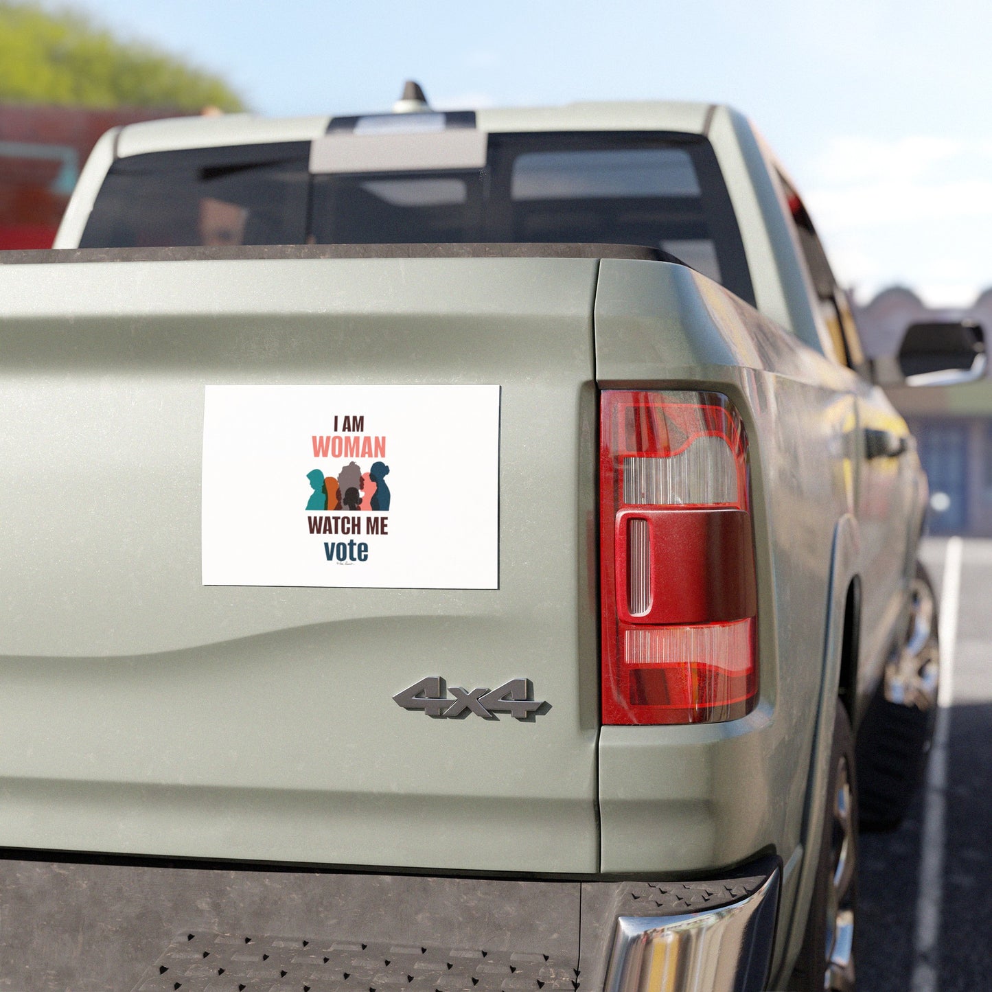 Rear view of a pickup truck displaying a weatherproof vinyl car magnet from Printify, with the message "I am Woman, Watch Me Vote," alongside illustrations of three women.