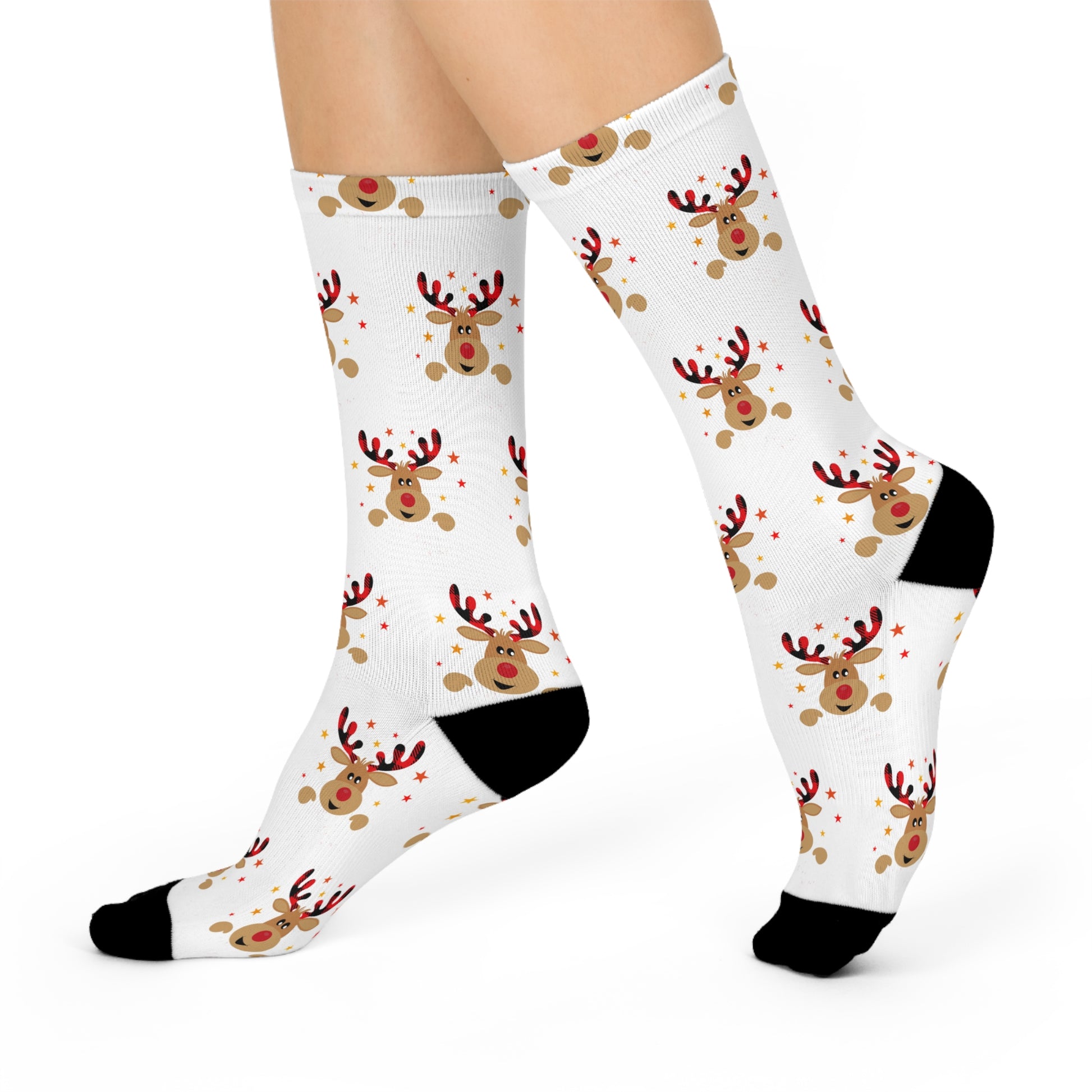 A person is wearing Printify's Festive Reindeer Crew-Socks, which boast a holiday cheer with reindeer and red star patterns along with black toes and heels. These unisex, cushioned socks add a touch of joy to any outfit, making them perfect for the season.