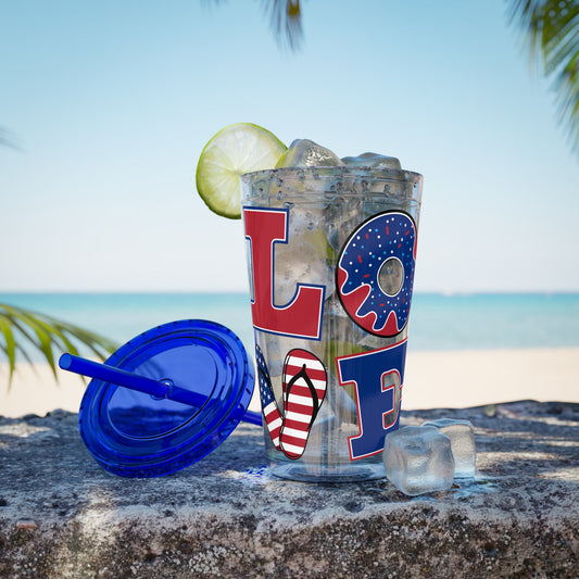 A Printify Love USA tumbler with a lime and a straw on the beach.