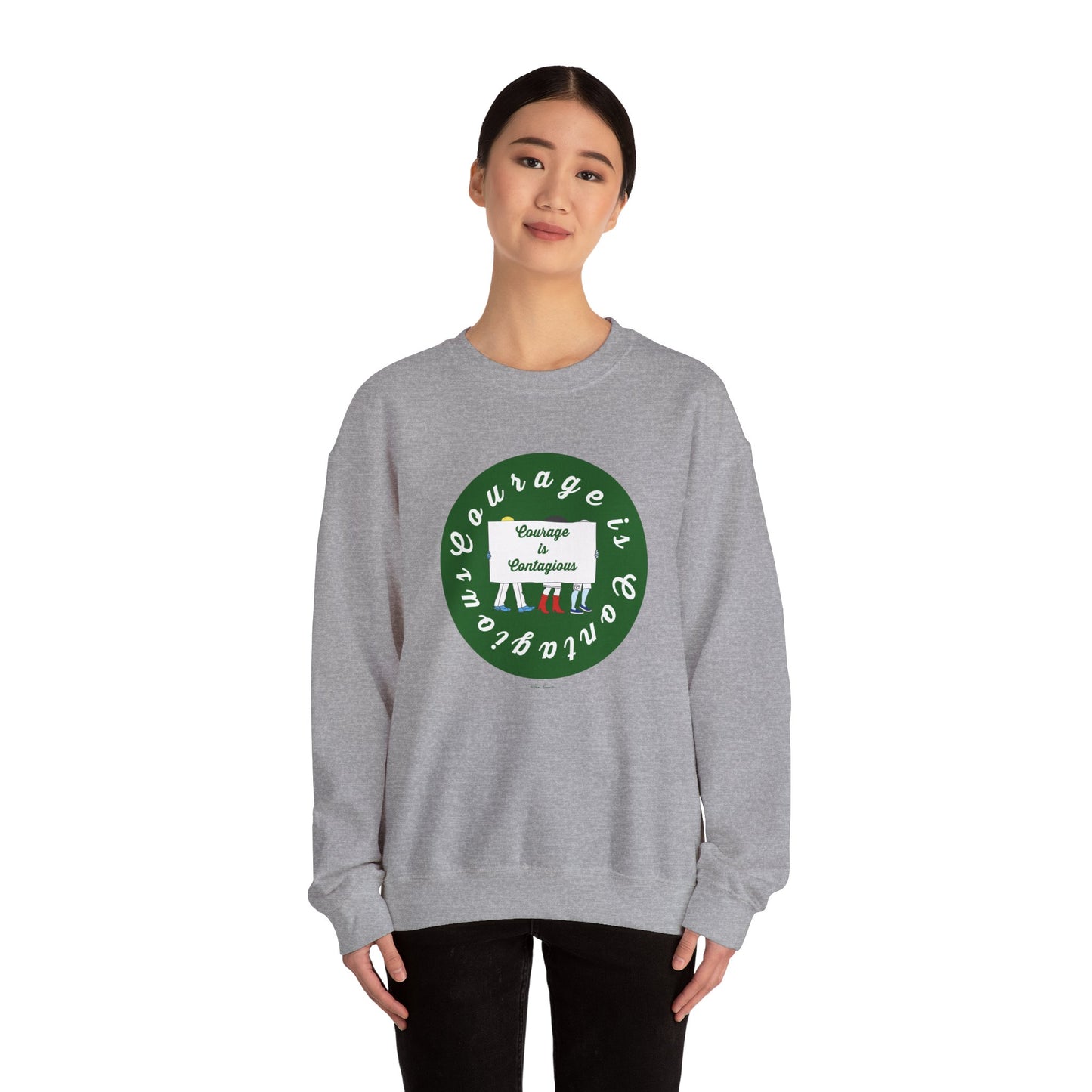 A woman wears the Printify Unisex Crewneck Sweatshirt: Courage is Contagious | Protest, featuring a green circular design and inspiring text—ideal for anyone seeking motivational apparel.