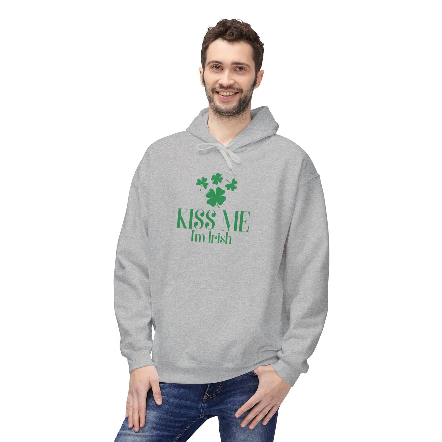 A man wearing the Printify "Kiss-Me I'm Irish Hoodie: St. Patricks Day Shamrock Pullover," featuring green text and shamrocks, stands smiling at the camera.