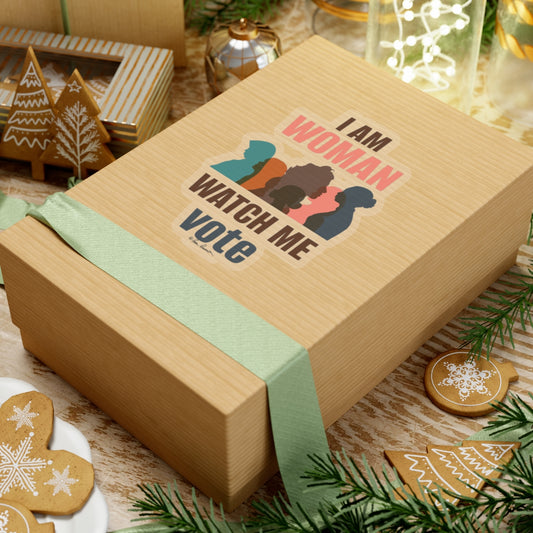 A gift box featuring a "Printify American made Voting Women's Sticker" with "i am woman watch me vote" printed on it, surrounded by Christmas cookies and decorations on a wooden table.