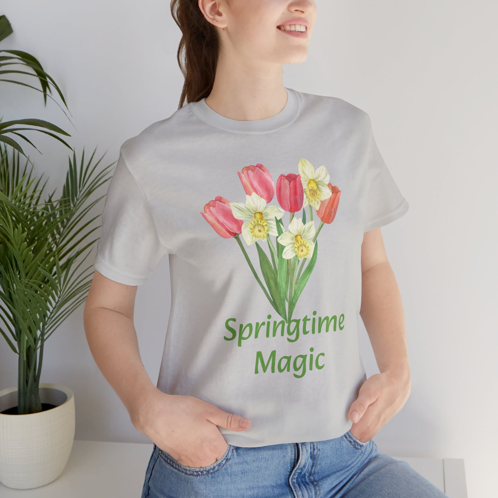 Woman wearing a gray Unisex Springtime-Magic T-shirt made of cotton by Bella + Canvas, with a floral print design.