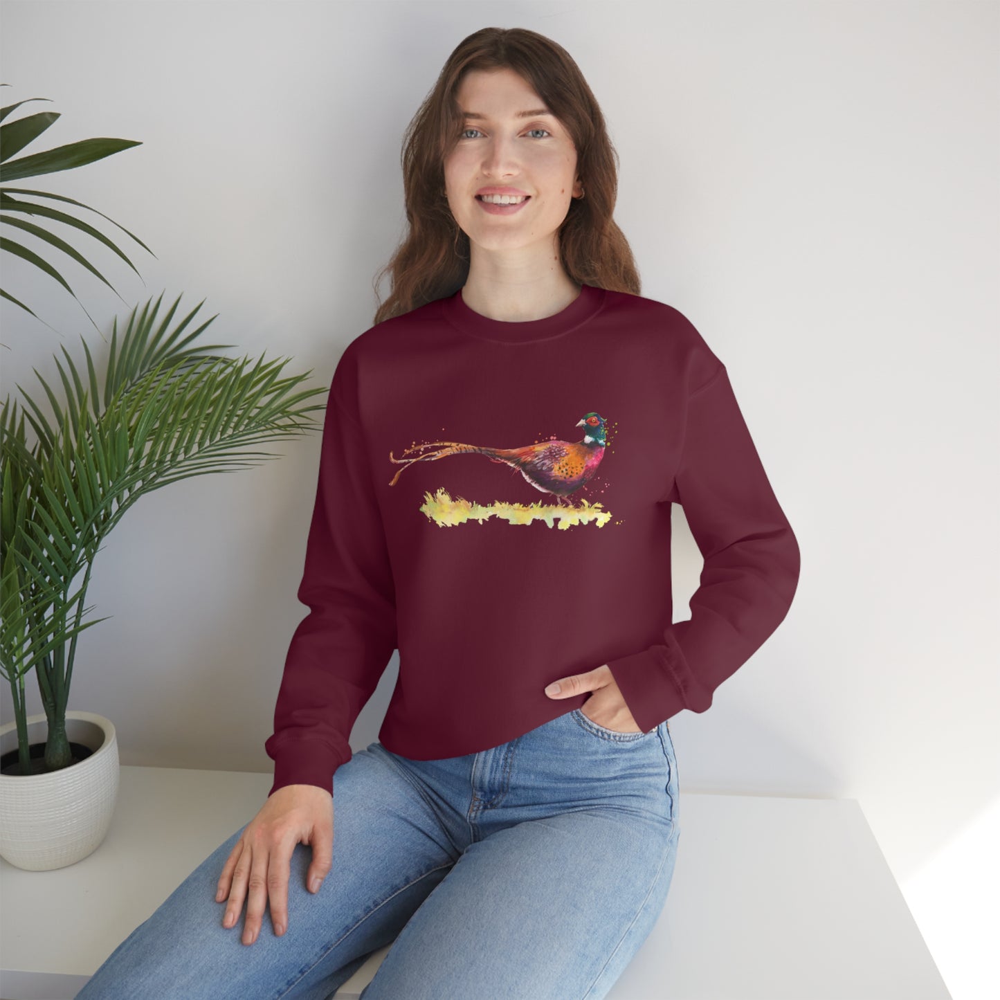 Mock up of a woman sitting on a surface while wearing the Maroon shirt