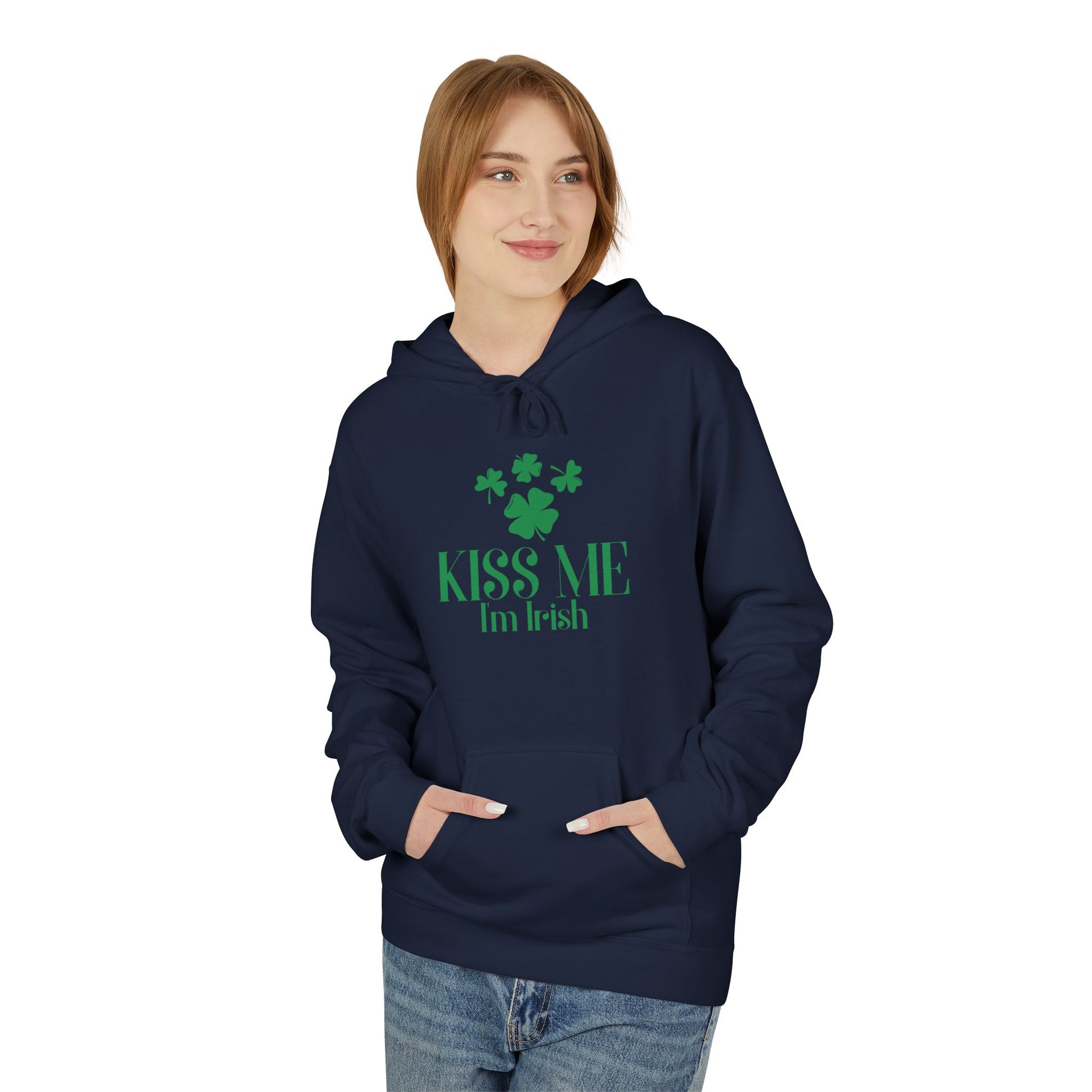 A person wears the Printify "Kiss-Me I'm Irish Hoodie: St. Patricks Day Shamrock Pullover," a navy hoodie featuring green shamrocks and "Kiss Me I'm Irish" text, standing with hands in the front pocket.