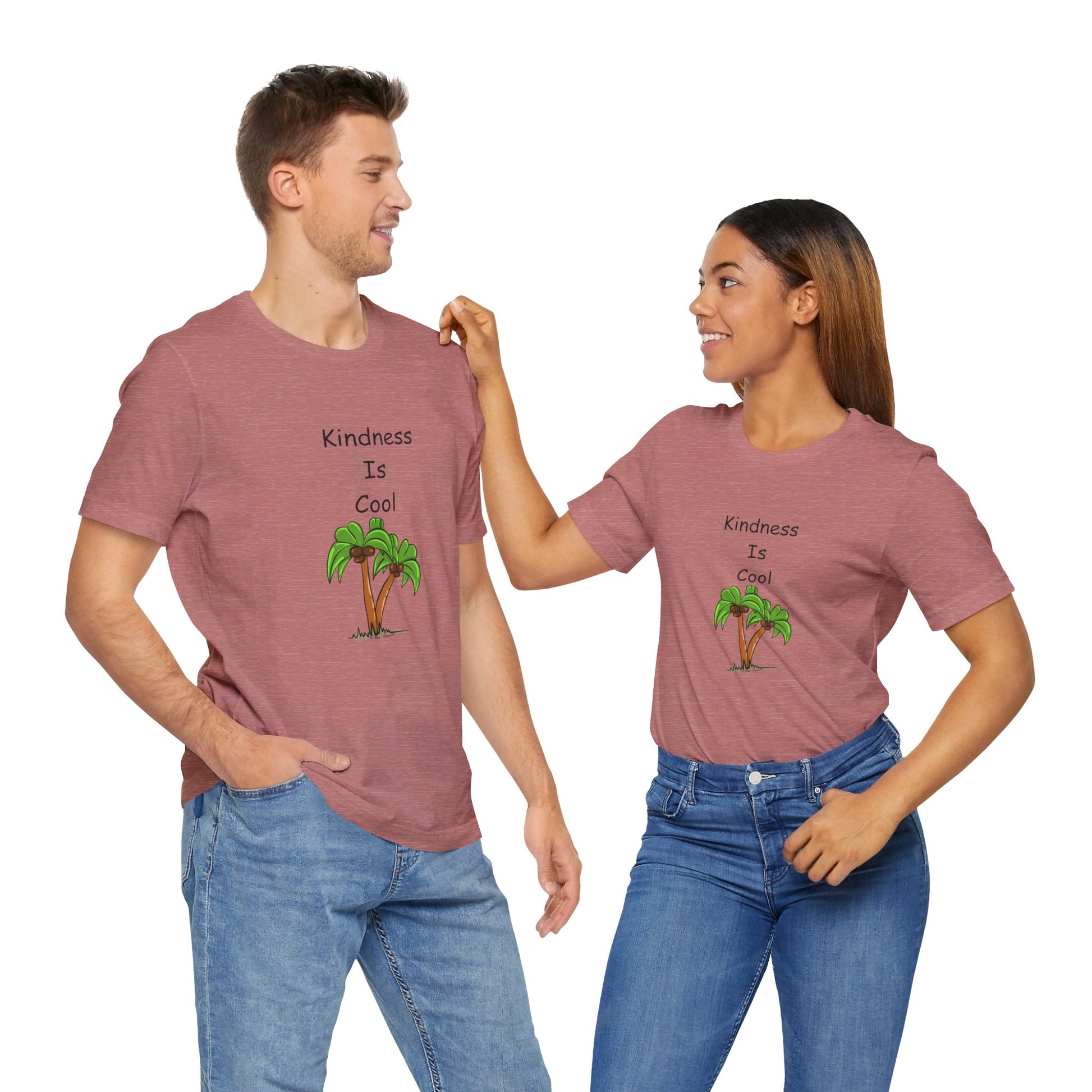 Two people wearing matching Printify Unisex Kindness-Is-Cool T-Shirts from Bella+Canvas, adorned with palm tree graphics, smile and gaze at each other. The soft cotton jersey fabric ensures maximum comfort while spreading a positive message.