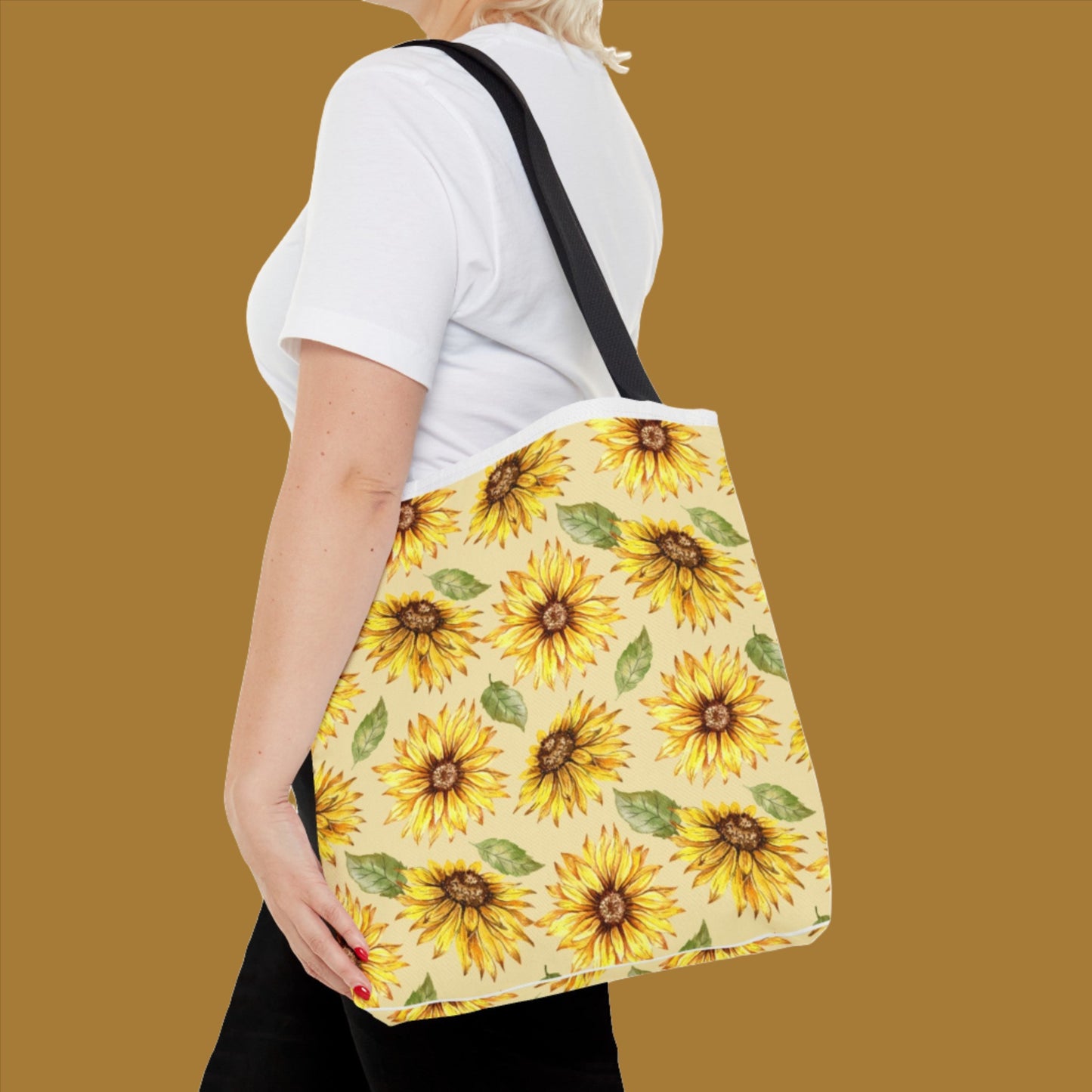 Woman in a white t-shirt carrying a large Yellow Floral Tote Bag with a bright sunflower print, viewed from the side by Printify.