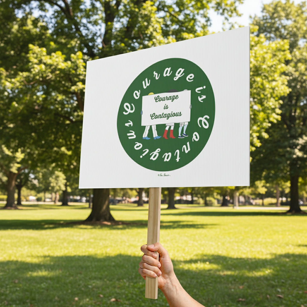 A hand holds the Printify Courage-is-Contagious Protest Sign (18" x 24", 1-sided) in a park, featuring "Courage is Contagious" in a green circle with small sock illustrations below.