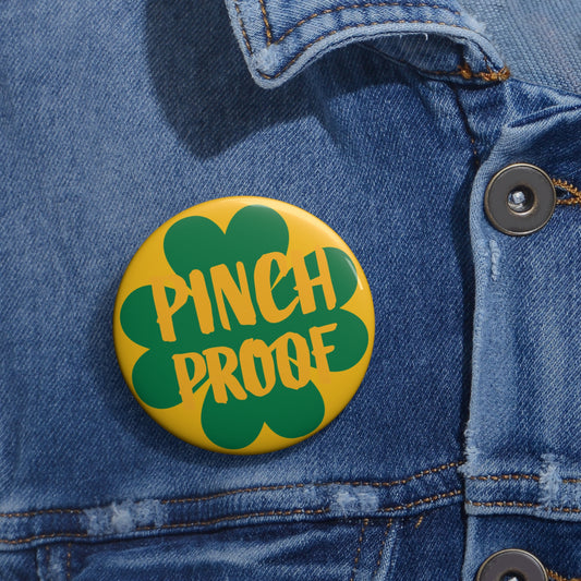 A Metal Pin Button by Printify, featuring a green four-leaf clover and “PINCH PROOF” on yellow, is pinned to a blue denim jacket—making it the perfect St. Patrick’s Day badge. Available in 2 round sizes.
