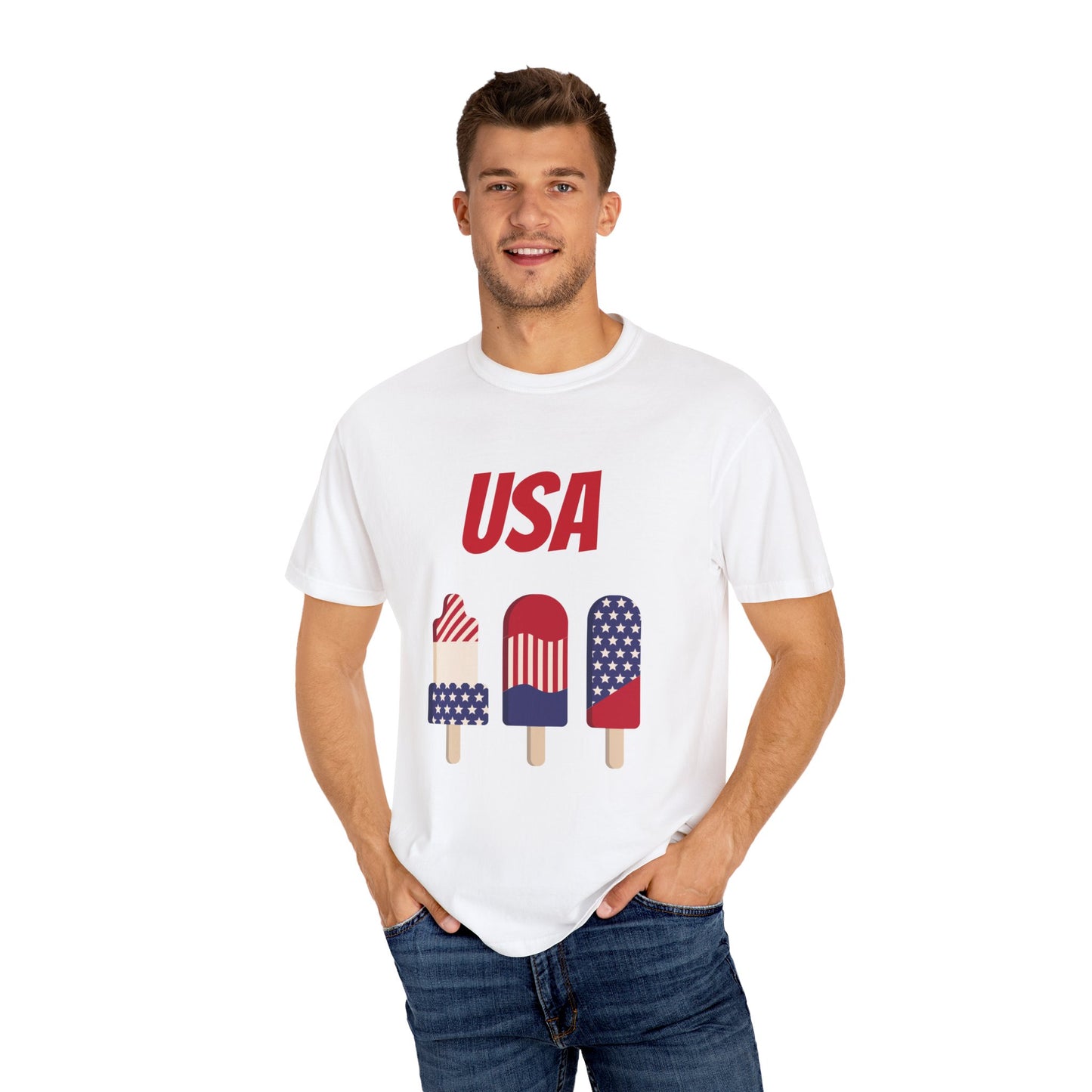 A man wearing a white Unisex USA T-shirt: 3 colors; Cotton; Comfort Colors 1717 from Printify, with popsicles in American flag colors, made from 100% ring-spun cotton for ultimate comfort, smiles with his hands in his pockets.