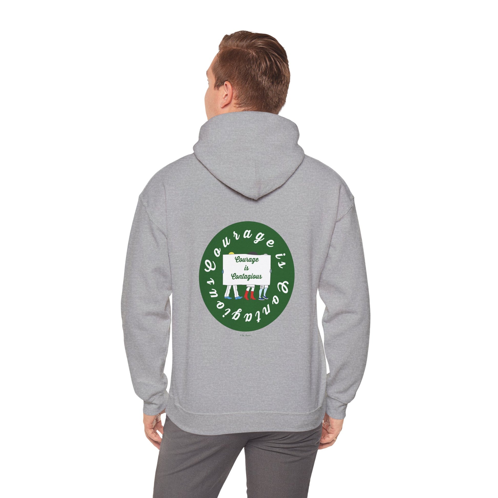 A man wears the Printify Courage Is Contagious Hoodie: Mental Health Awareness, a mid-weight hoodie with a circular green and white back design that reads, "Courage is contagious. Change encourages.