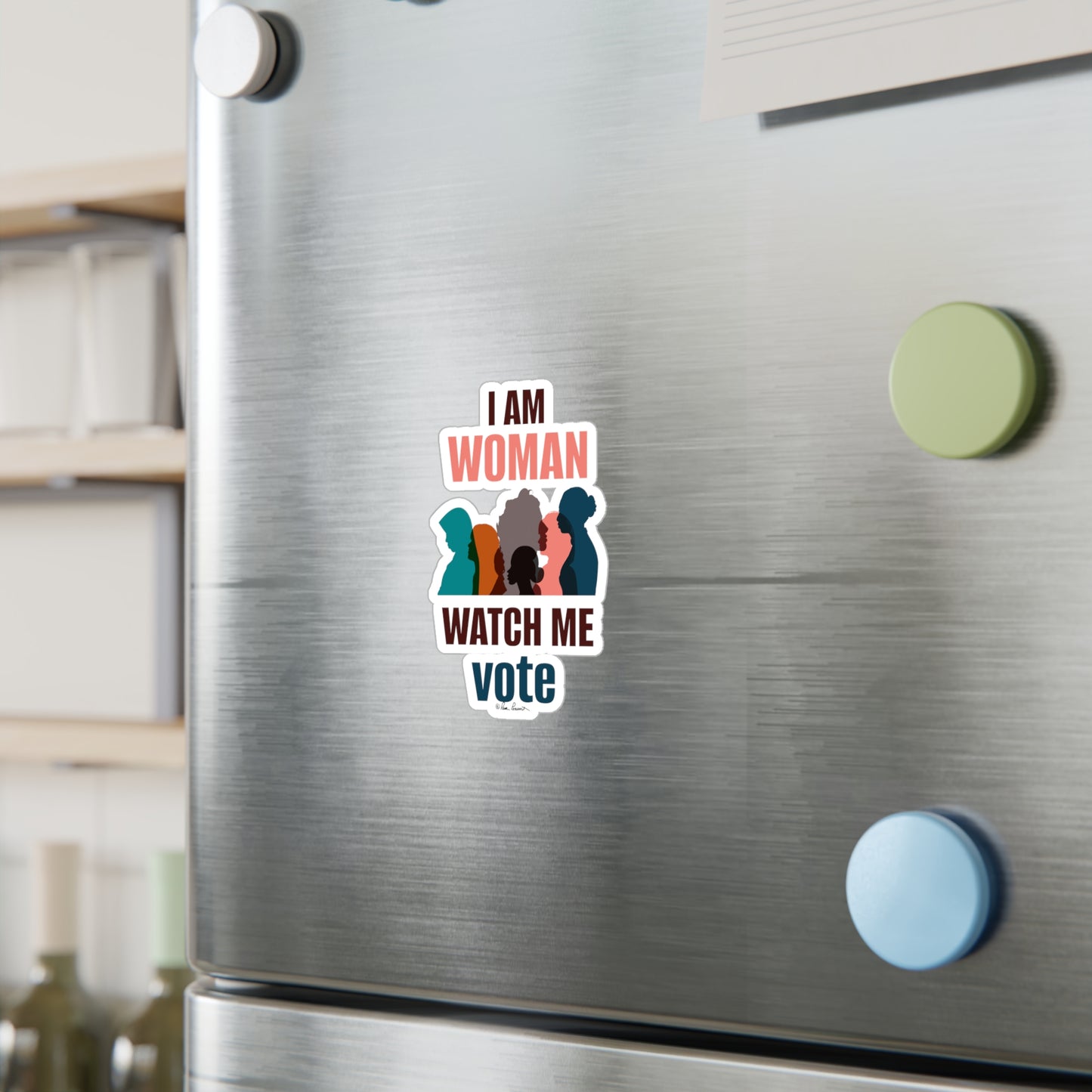 A stainless steel refrigerator door adorned with a colorful Printify Voting Women's Decals that says "i am woman watch me vote" featuring silhouettes of three women.