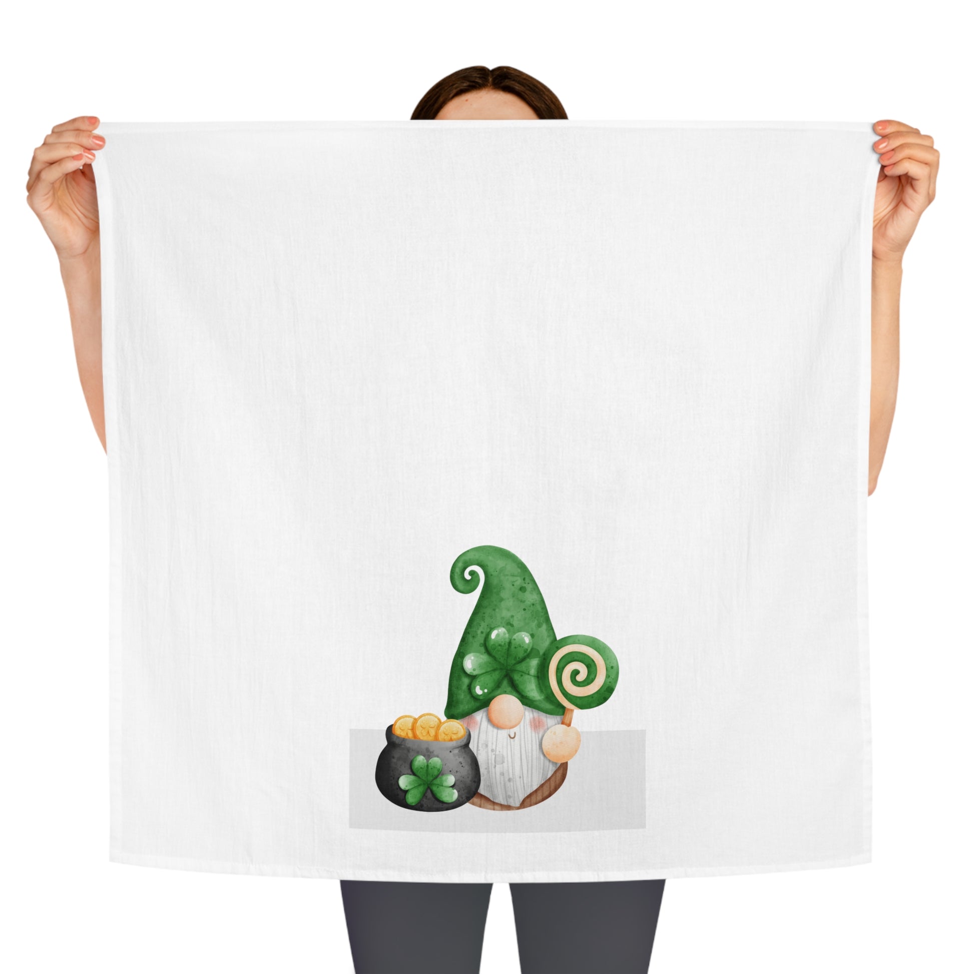 A woman holding up a Printify St. Patrick's Day towel with a green gnome on it.