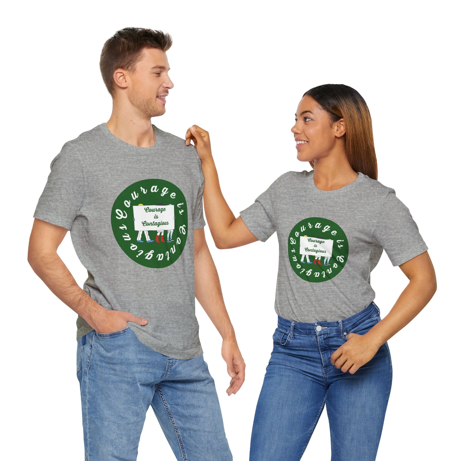 A man and woman wear matching gray Courage Is Contagious T-shirts from Printify, featuring a green circular design and activist graphics, and smile at each other in these unisex inspirational tees.
